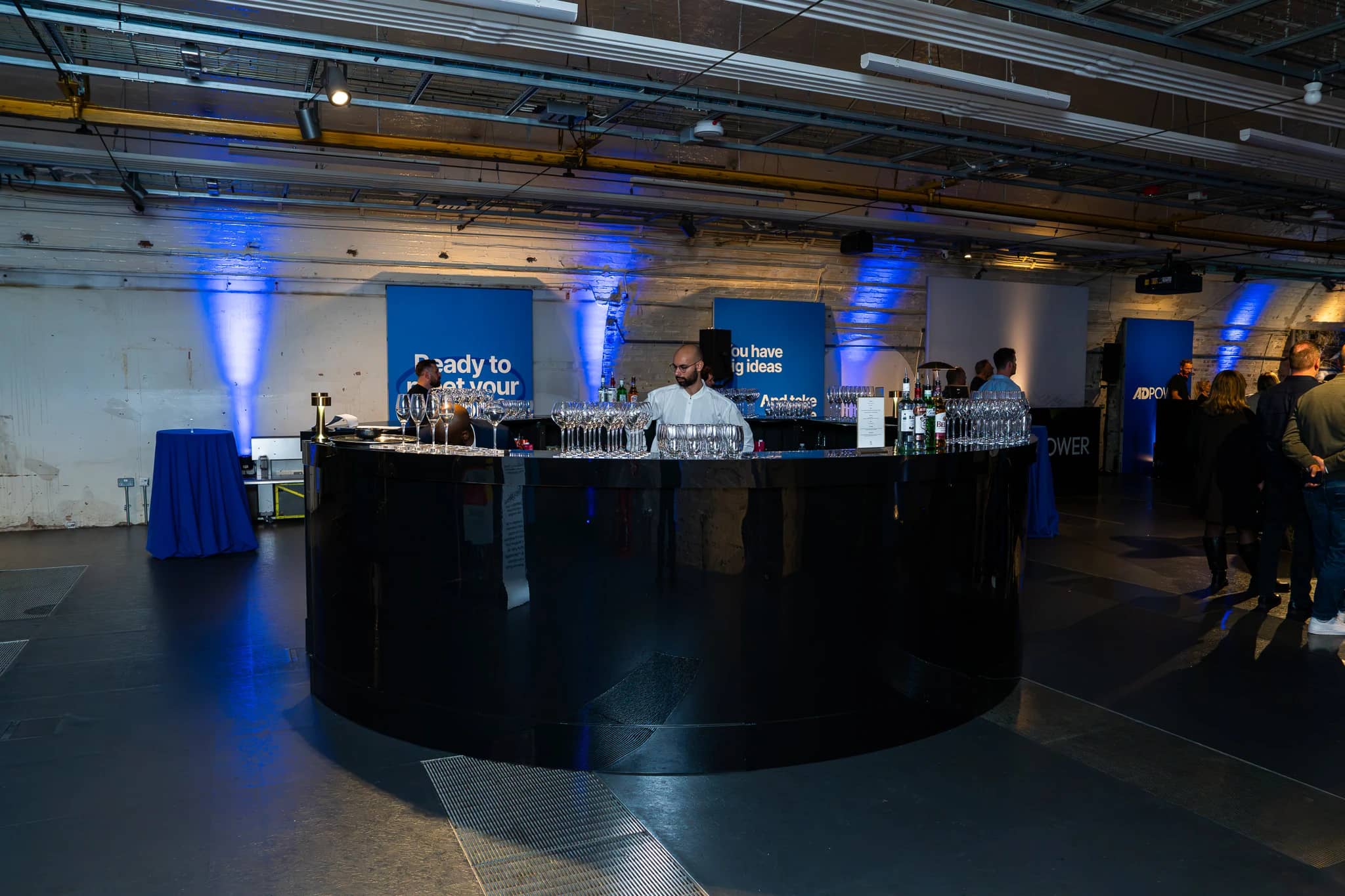 The circular black gloss bar in the Mail Rail Depot, with AdPower printed branding and blue uplighting behind.
