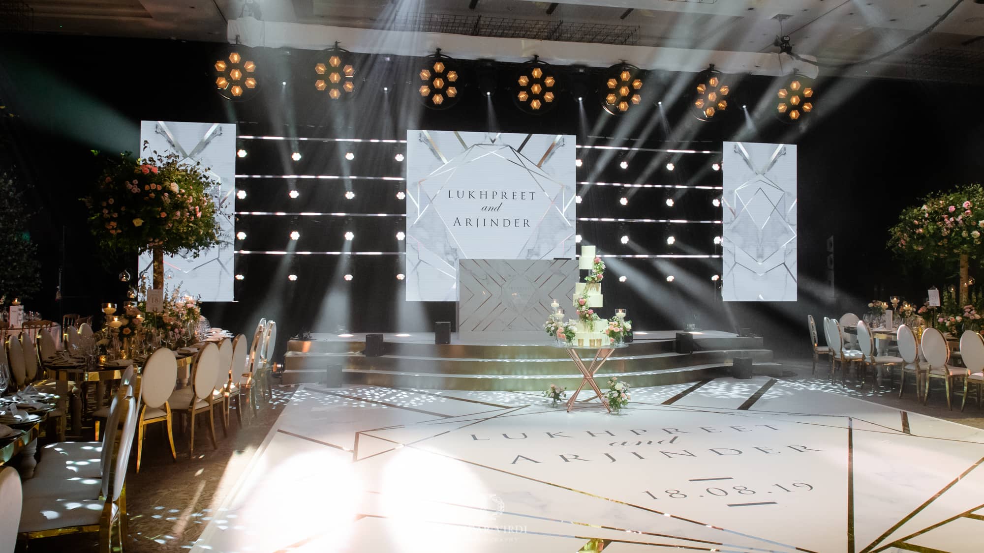 Luxury wedding at Hilton London Bankside, the bespoke curved stage and printed dancefloor under show lighting, by Kudos AV