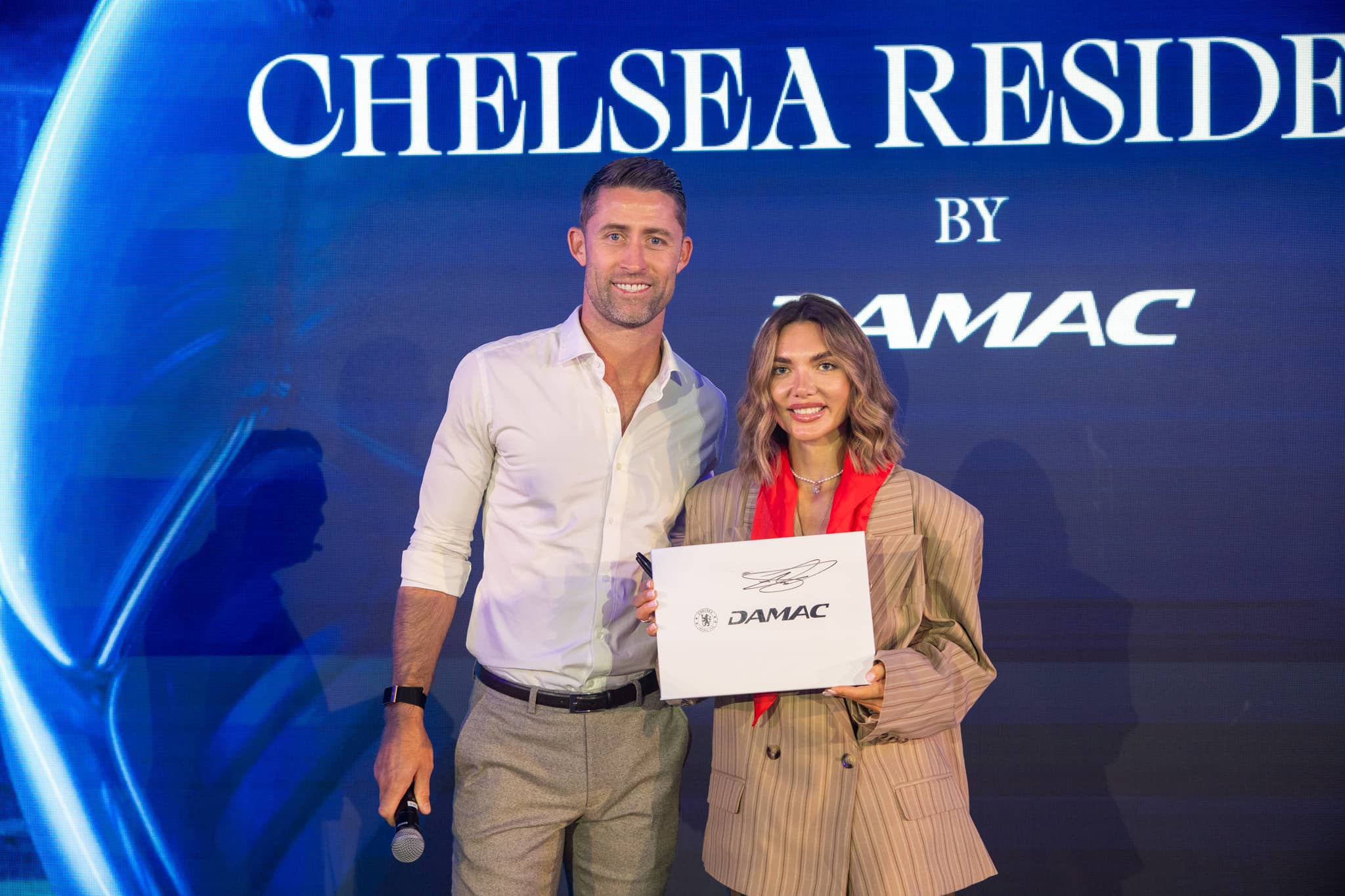 Gary Cahill presenting to a guest on stage at the Chelsea Residences launch