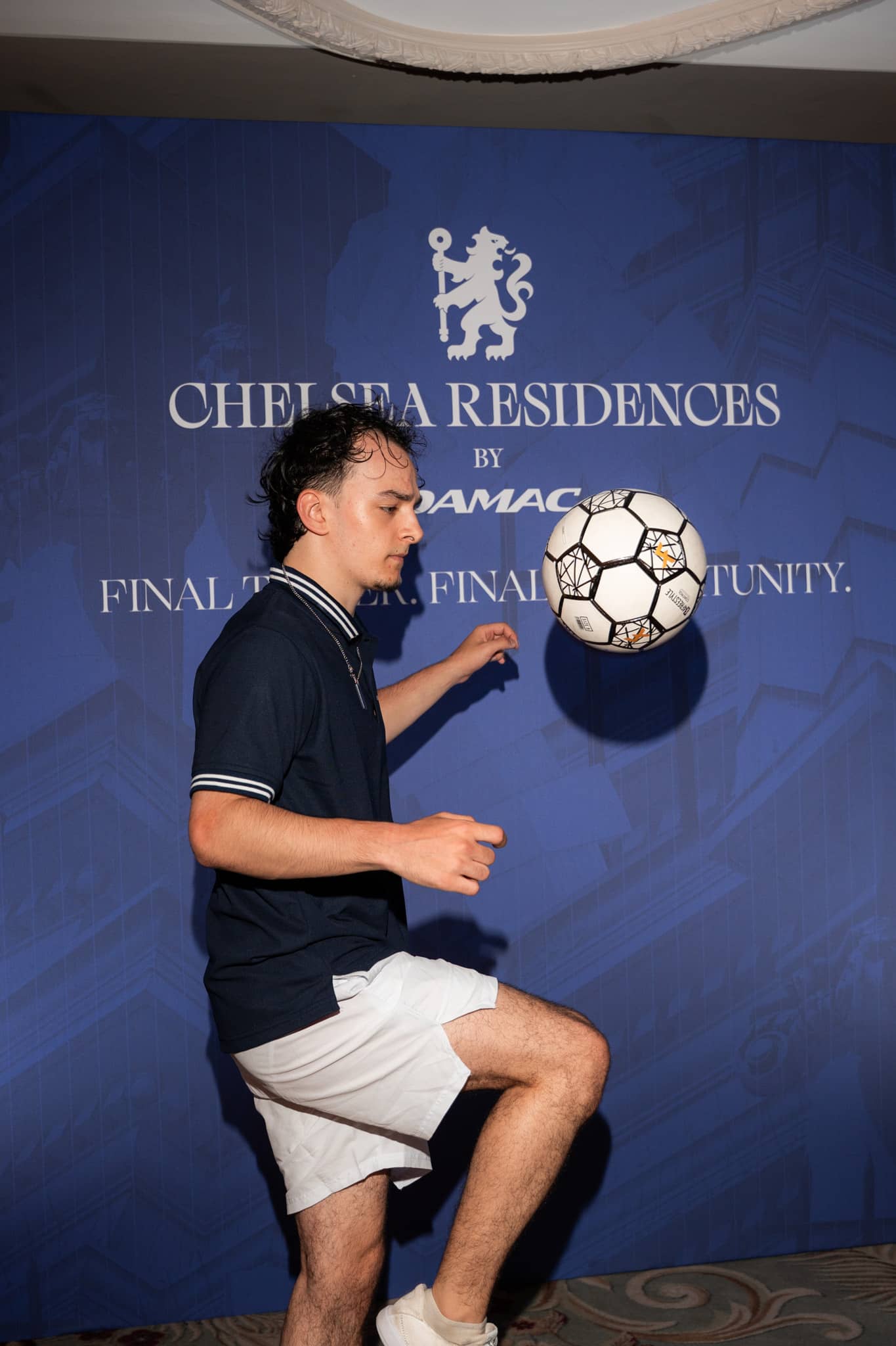 A football freestyler controlling the ball at the Final Tower, Final Opportunity wall