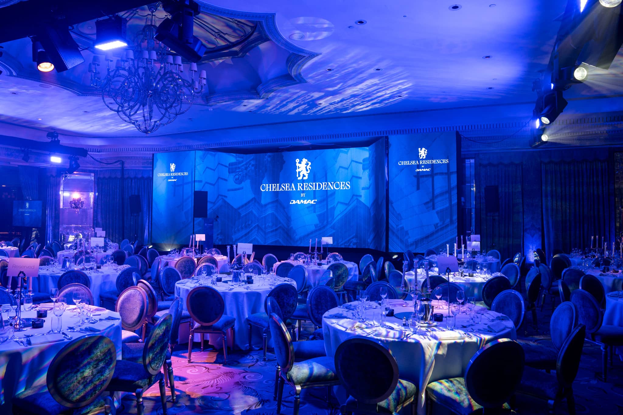 The Dorchester ballroom set for the Chelsea Residences launch, three-screen LED array lit deep blue