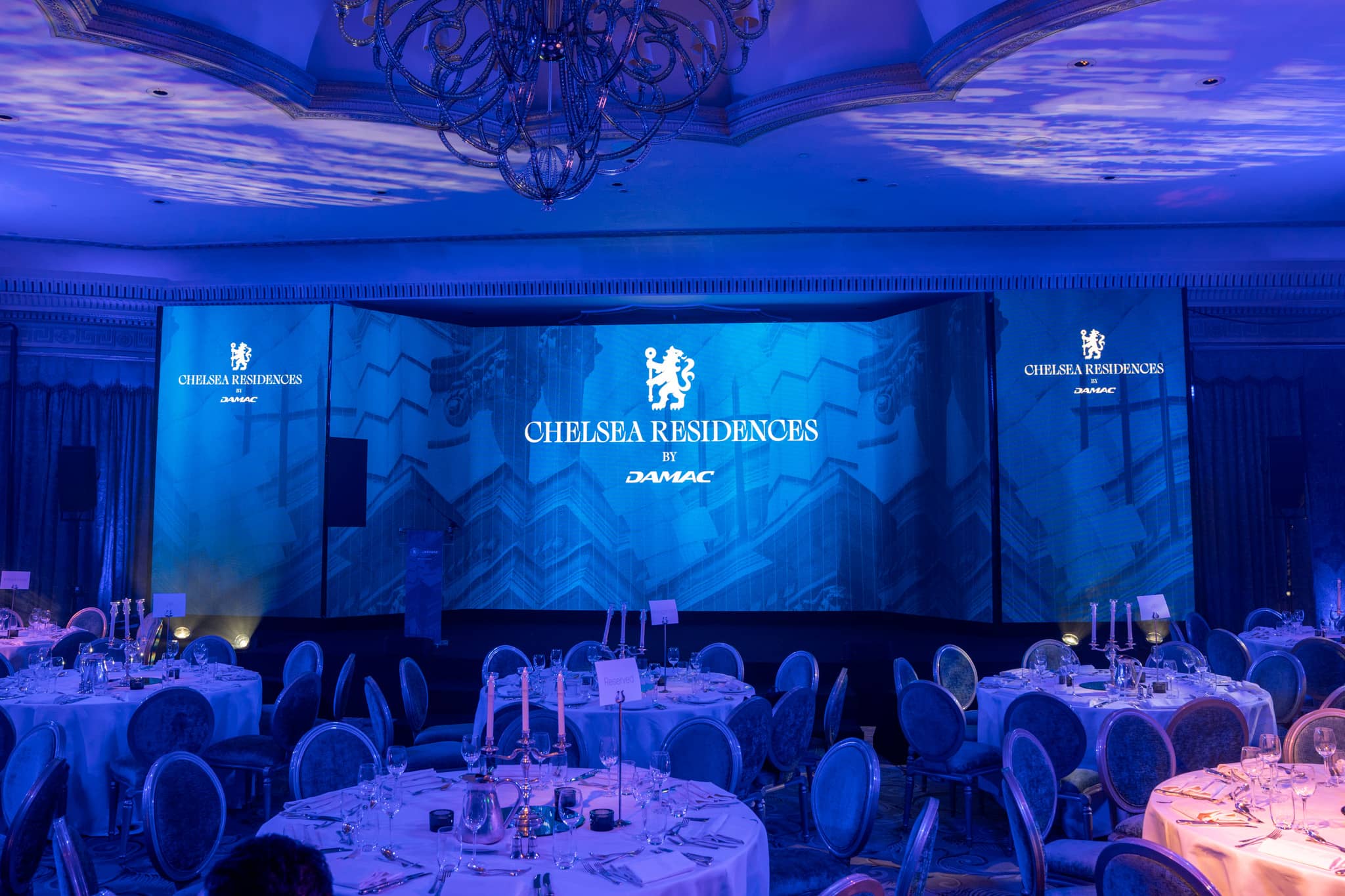 The Dorchester ballroom set for the Chelsea Residences launch, three-screen LED array lit deep blue