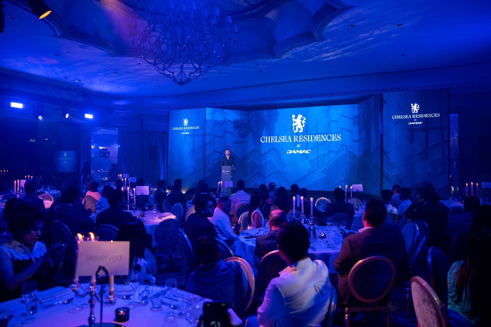 Property brokers and investors watching the presentation across the candlelit ballroom