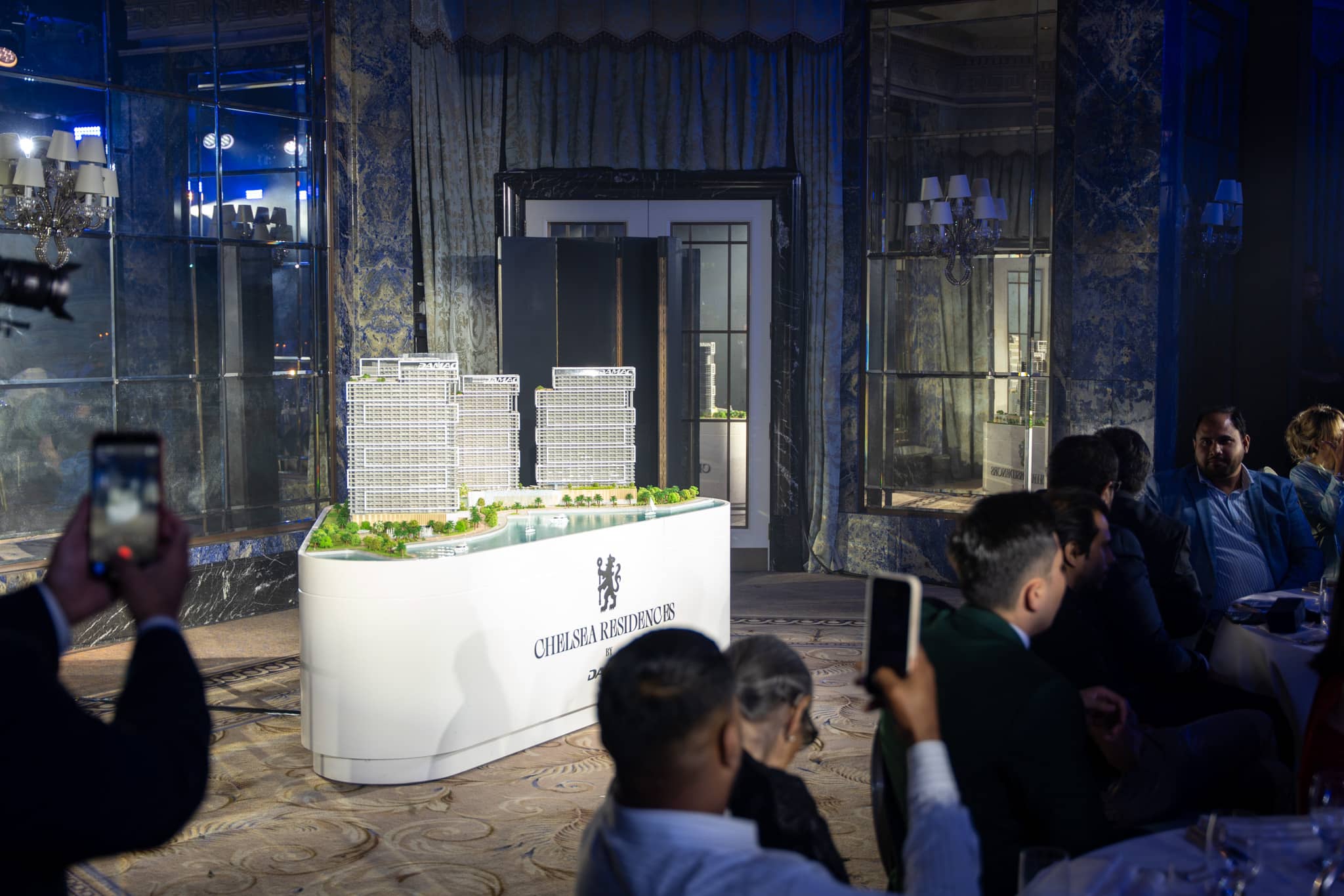 Guests photographing the illuminated Chelsea Residences model on its bespoke branded plinth