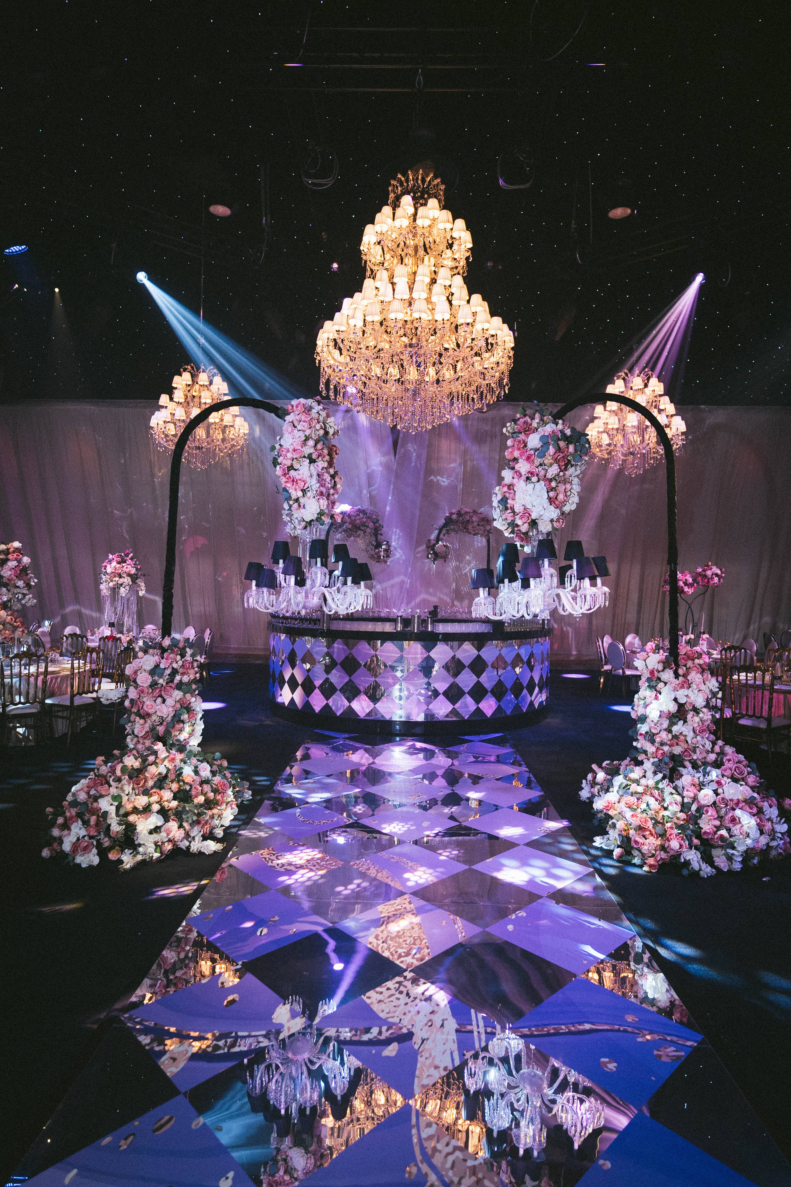 Grand crystal chandelier over the mirrored cake plinth and illuminated dancefloor, by Kudos AV