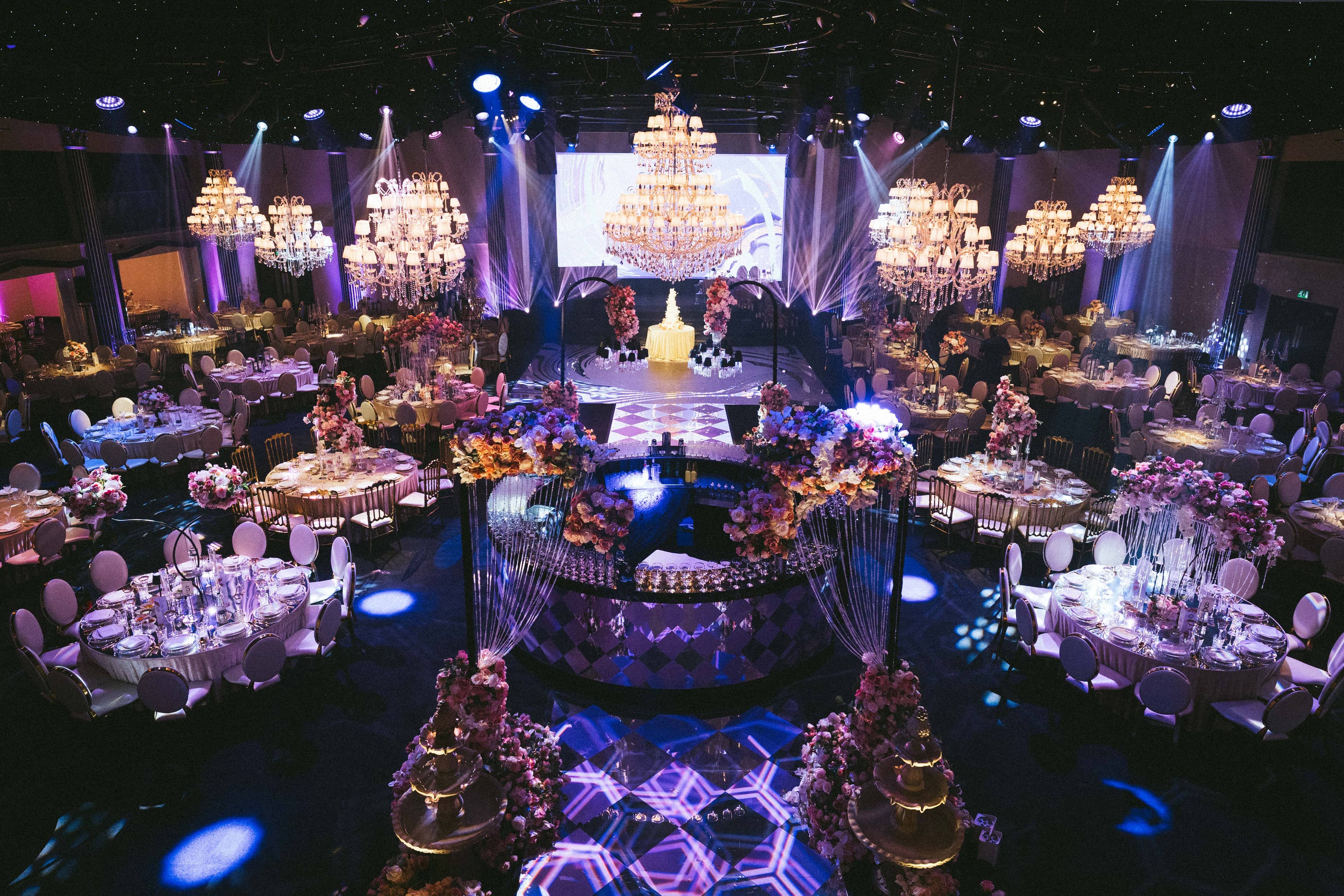 The room set wide with the illuminated geometric dancefloor and cake display, by Kudos AV