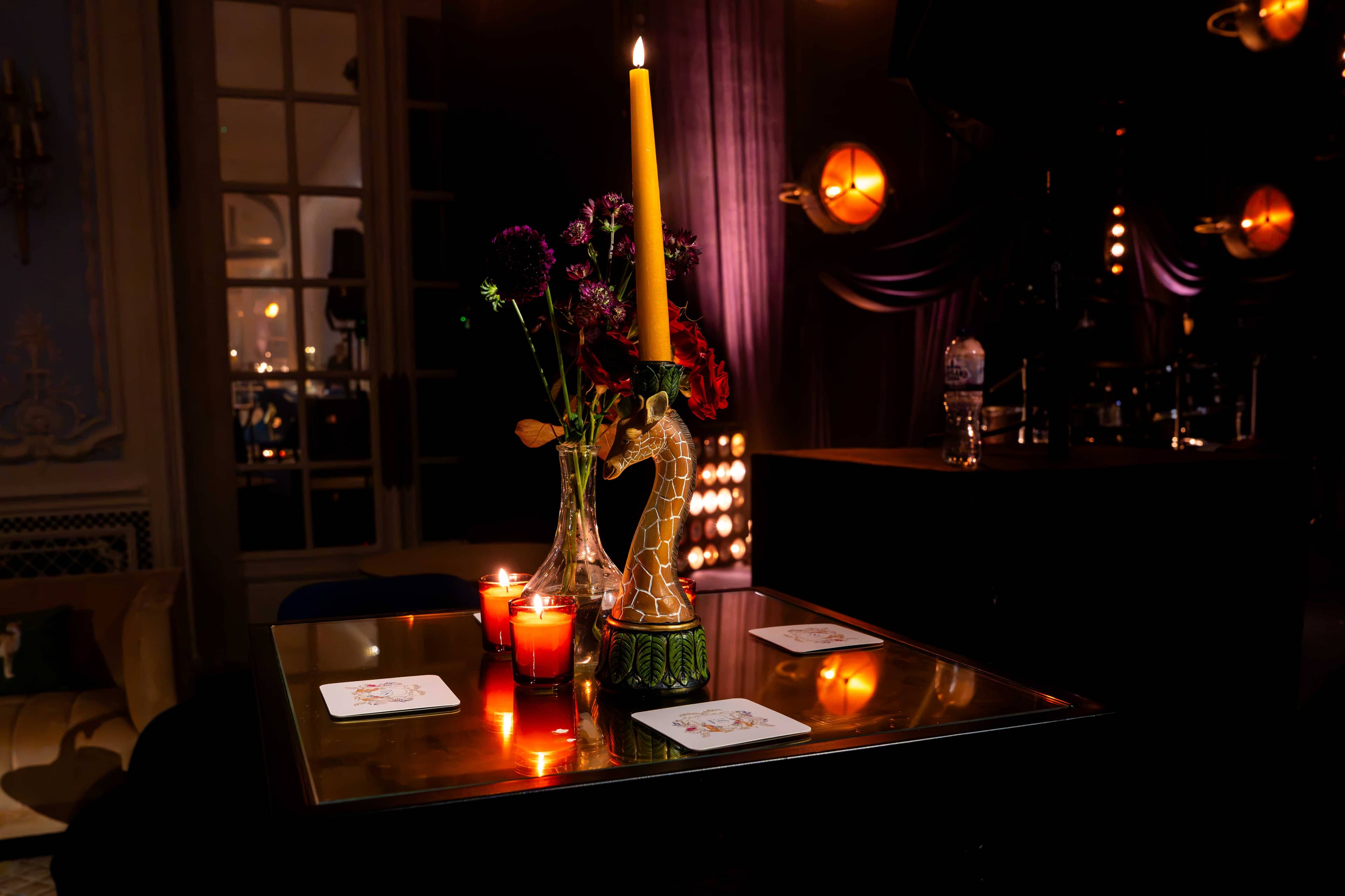 A candlelit table detail with retro lamps glowing behind, by Kudos AV