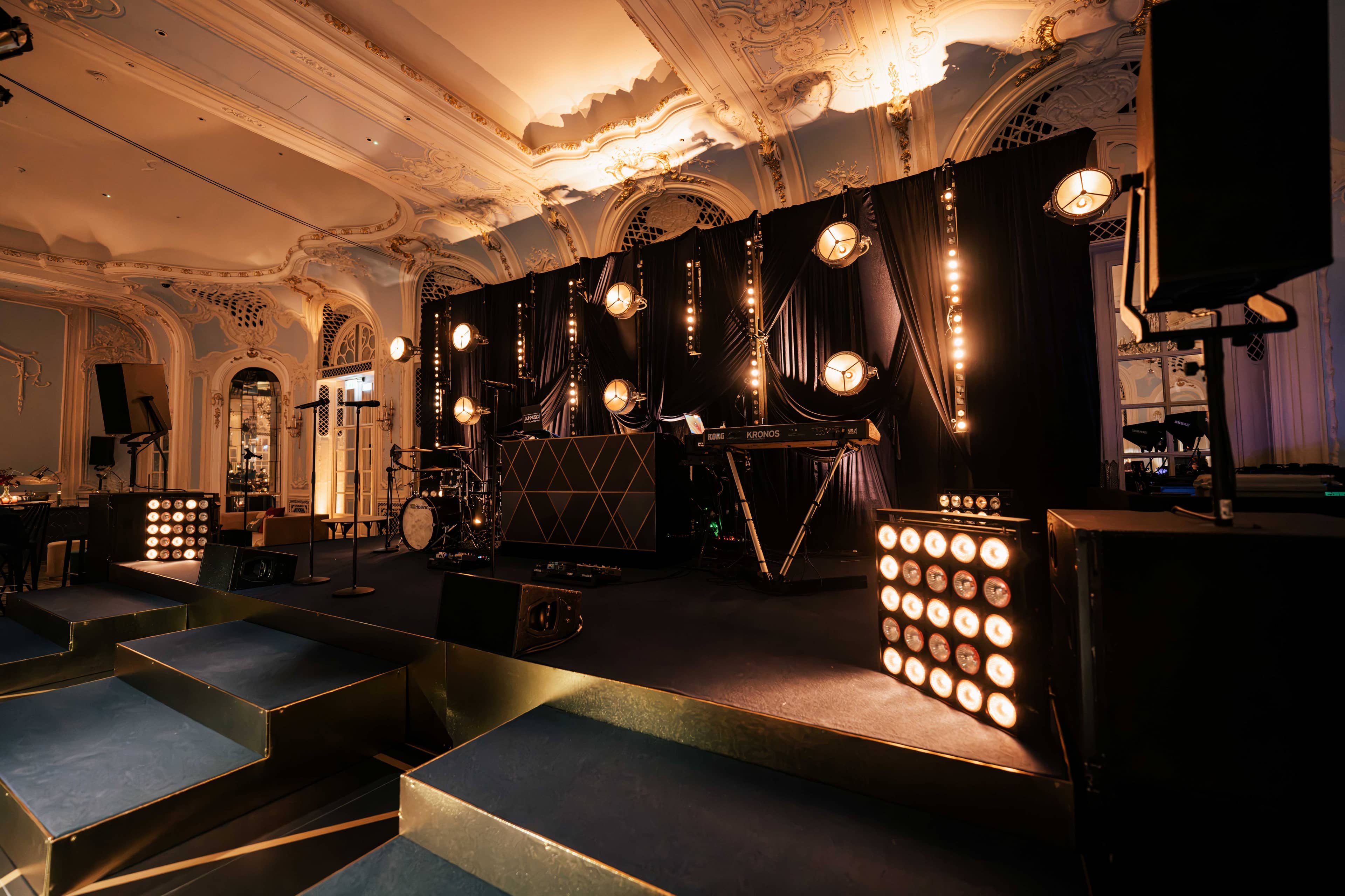 The stage front with matrix lamp panels and warm bulb strings, by Kudos AV