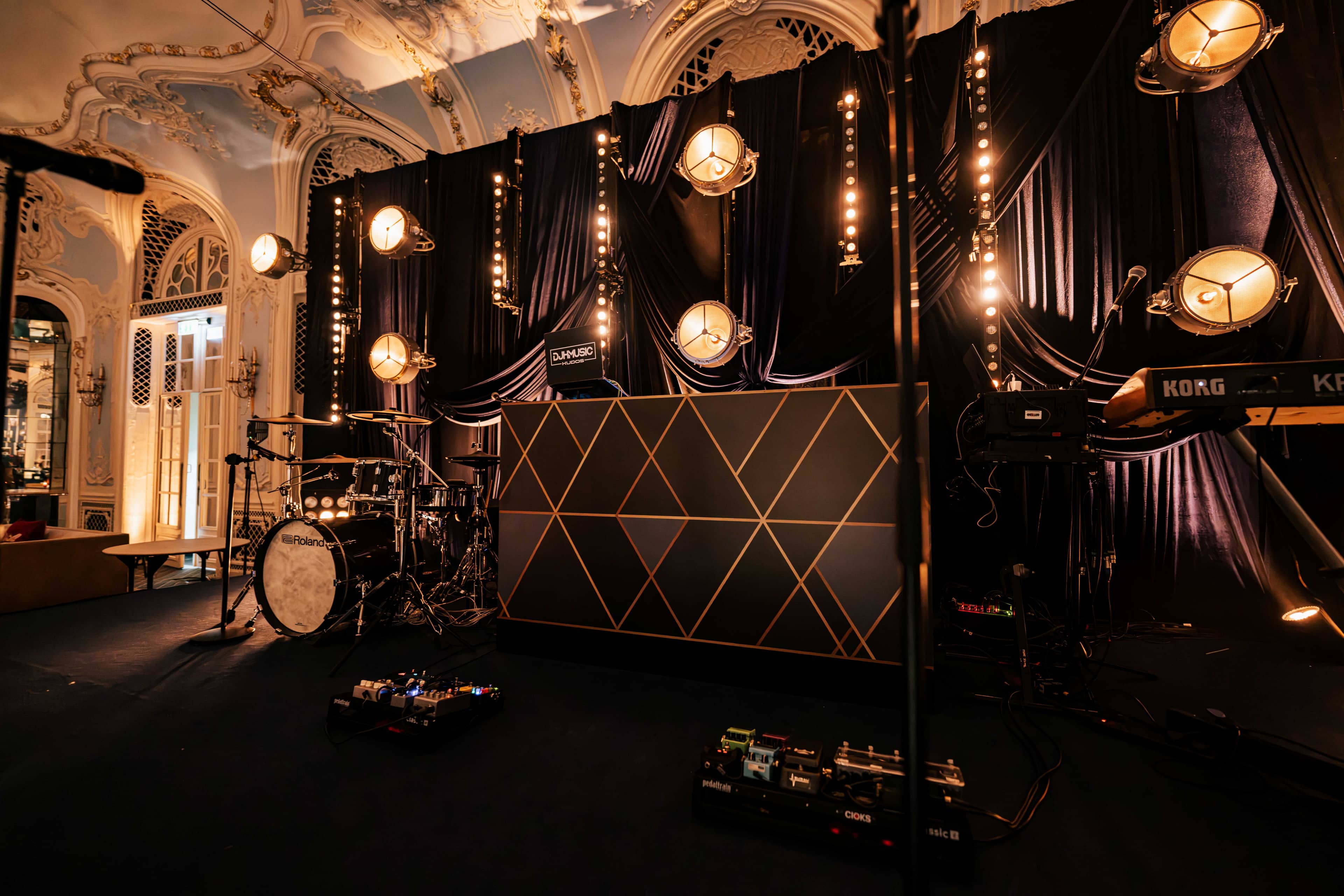 The stage from the side with drum kit and keys under retro lamps, by Kudos AV