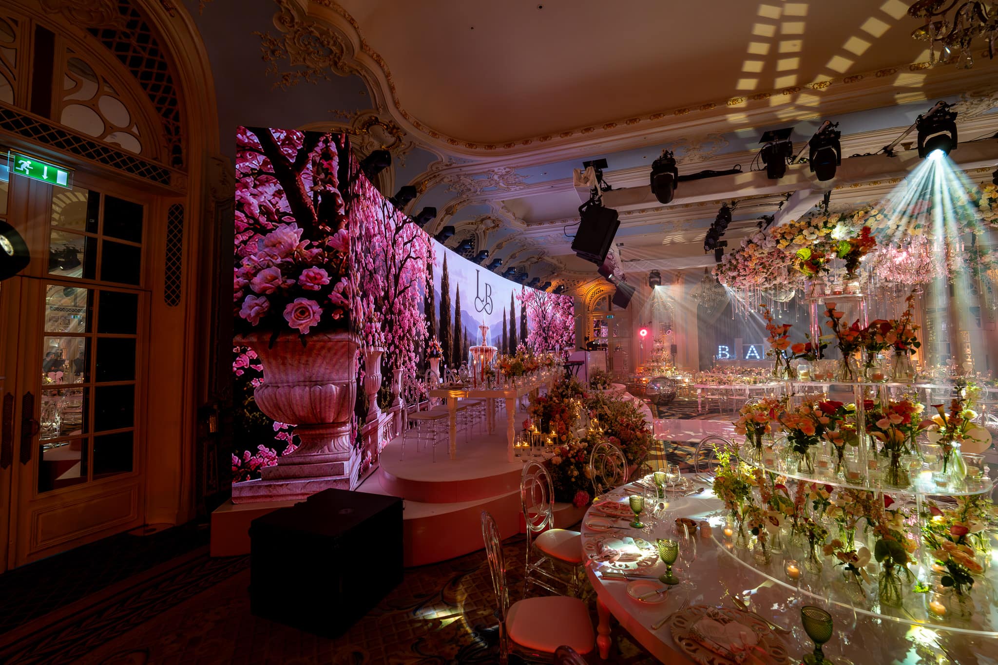 The curved LED screen and its LED return wrapping into the corner of the Lancaster Ballroom at The Savoy, blossom content running across both, by Kudos AV