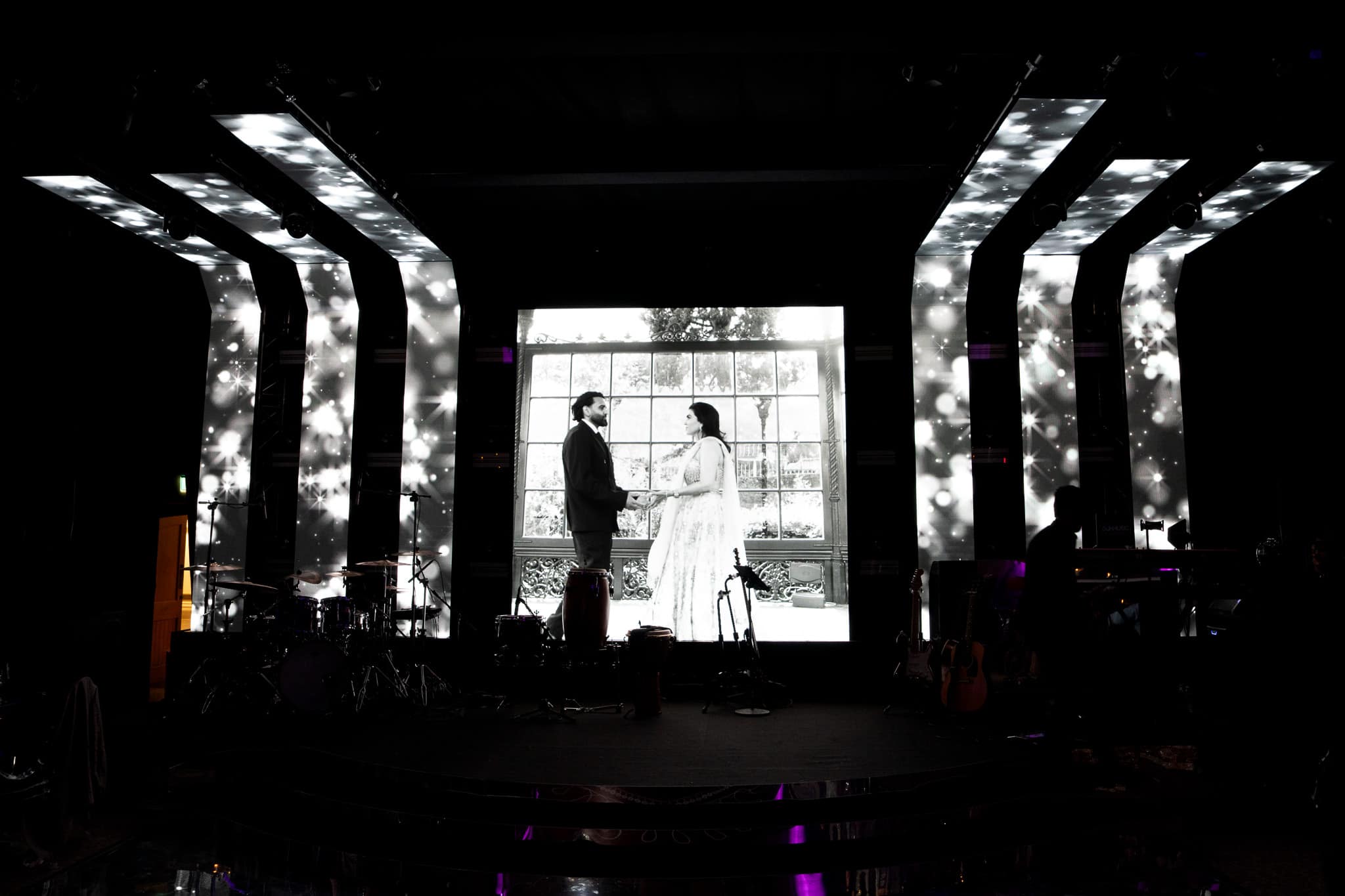 A couple on the illuminated stage under the LED arches at their Tatton Park wedding, produced by Kudos AV