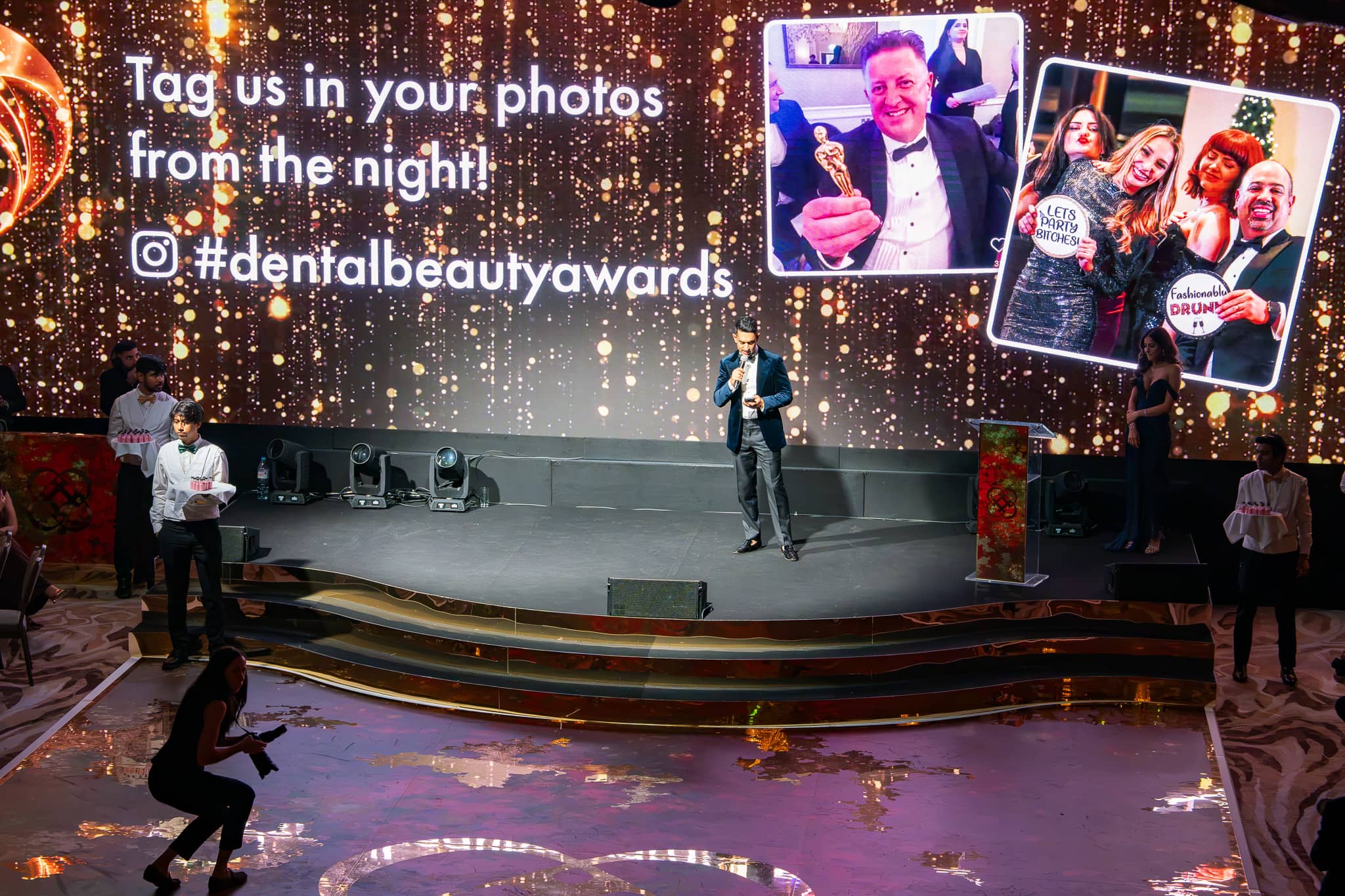 Guests on the awards stage in gold light, the LED screen behind them, Dental Beauty Partners Awards 2025 in the Great Room at Grosvenor House London, by Kudos AV.