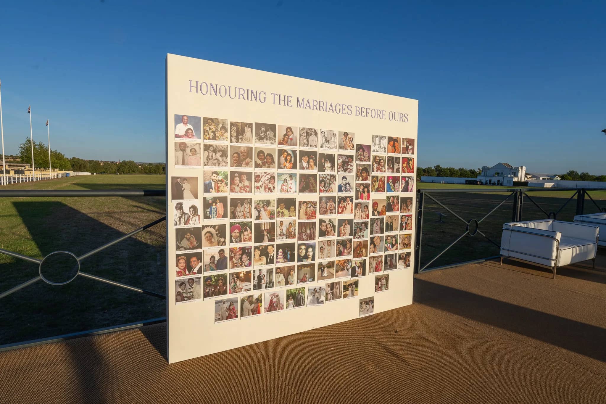A printed photo wall on the parkland reading Honouring The Marriages Before Ours, covered in family wedding photographs, Warwickshire, by Kudos AV