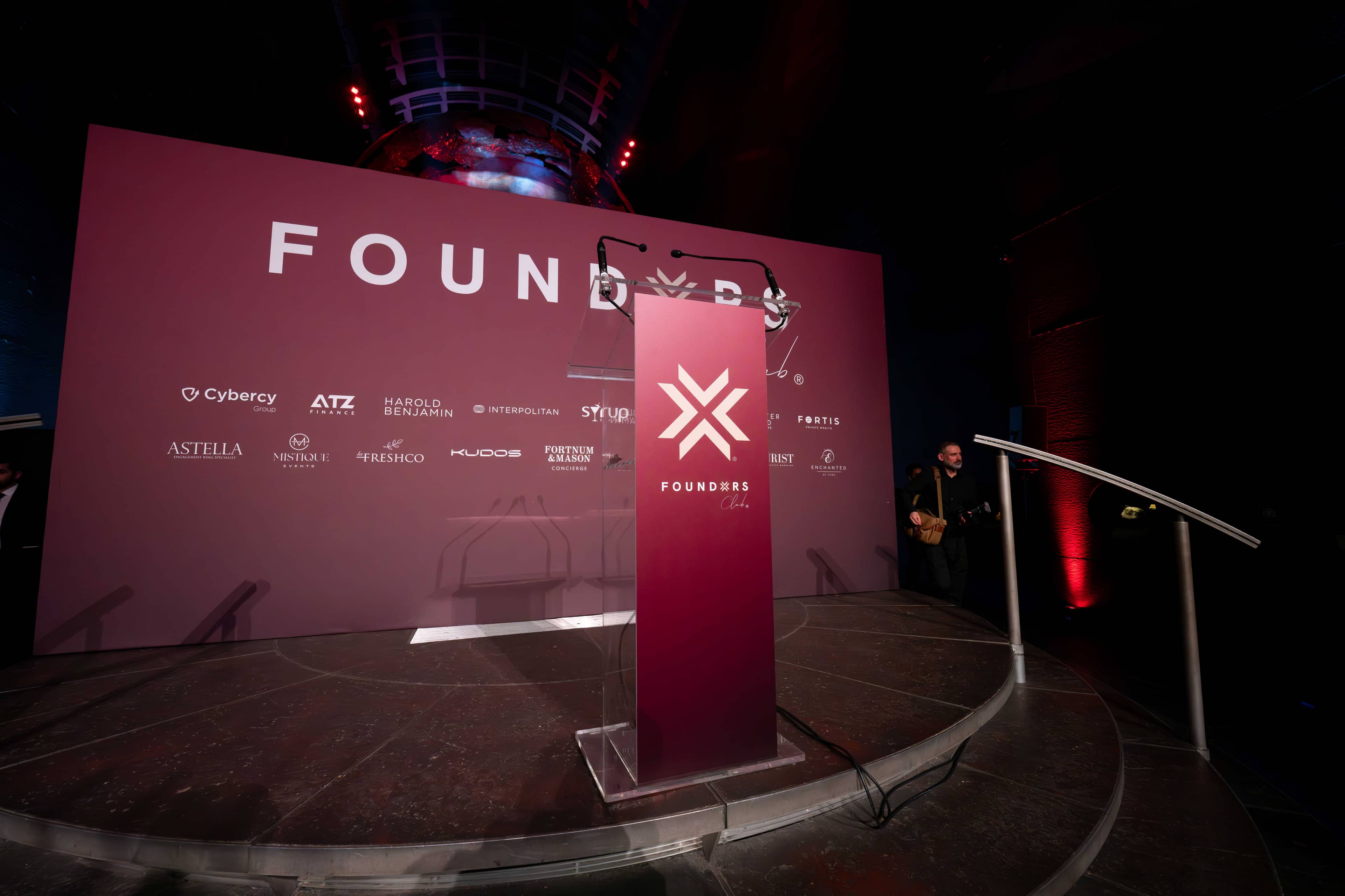 The FOUNDXRS mark and partner names on the screen behind the stage, FOUNDXRS Club black tie party in Earth Hall by Kudos AV.