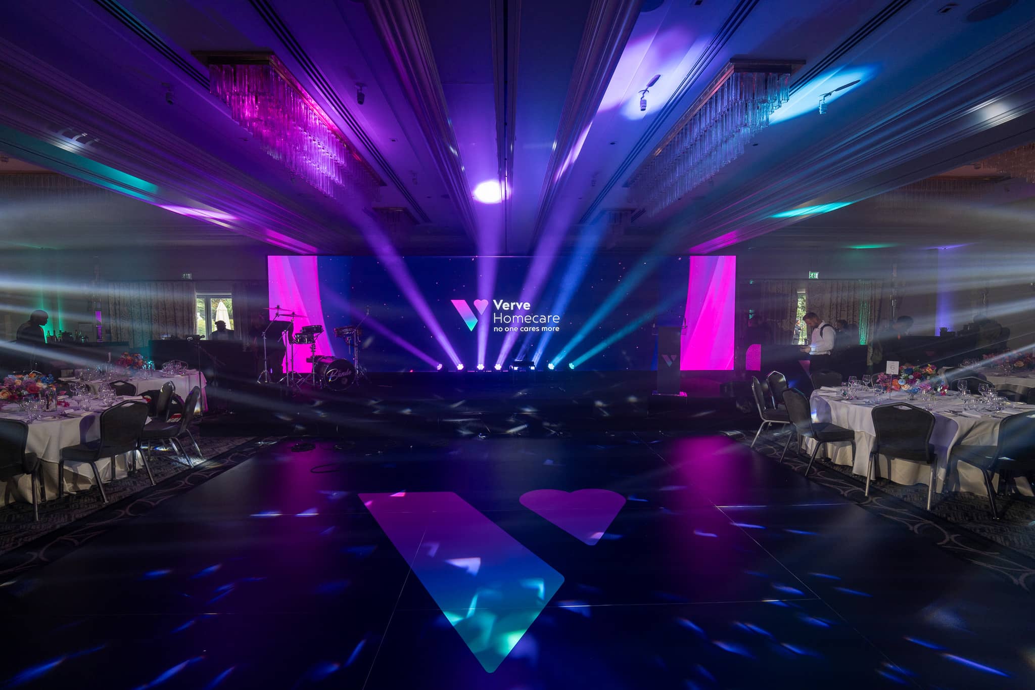 Moving head beams over the dancefloor and Verve logo at Verve Awards Night, with the Unilumin LED wall and its side columns behind the stage at Sopwell House.