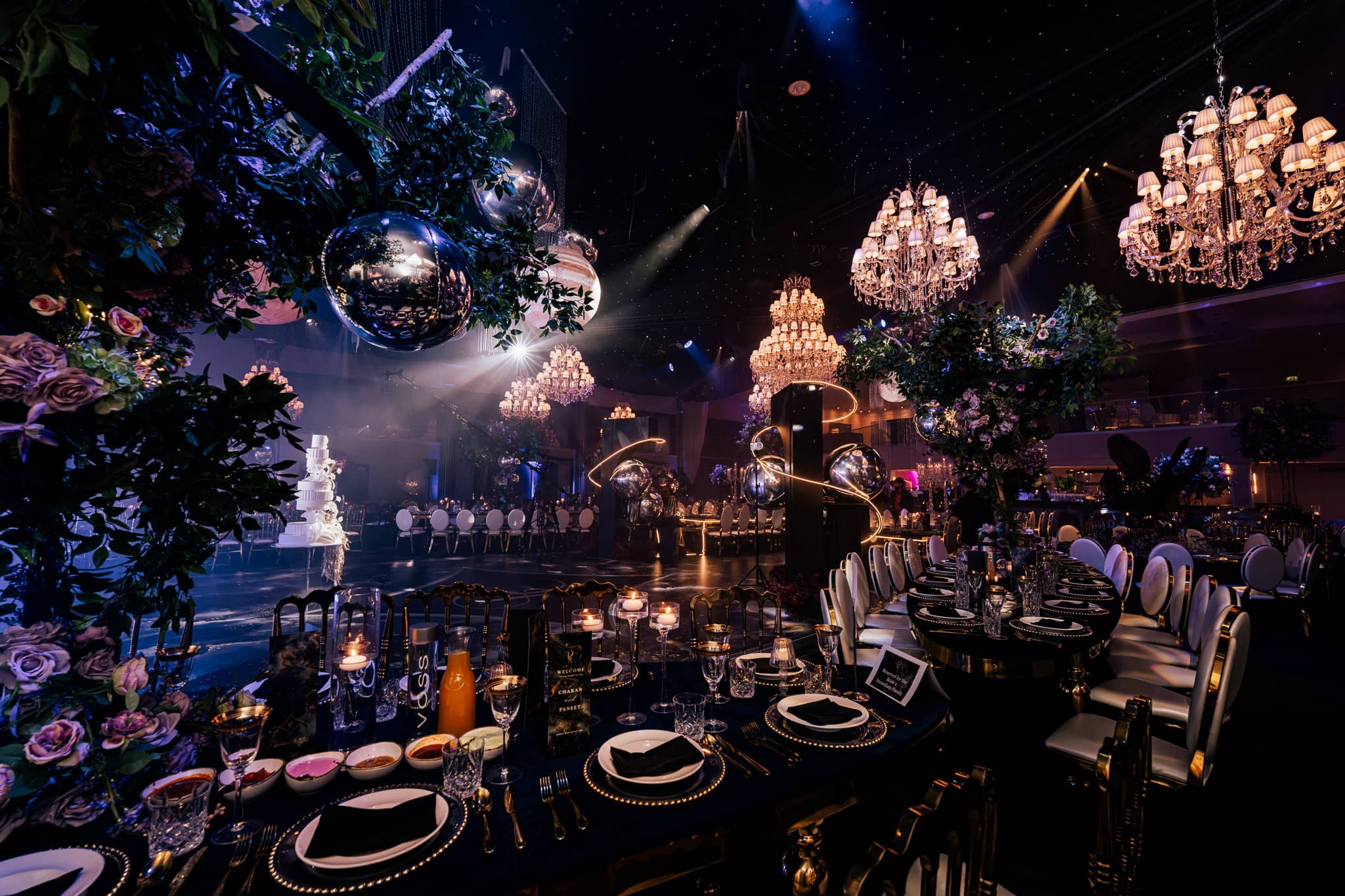 Table settings and floral installations under the chandeliers, by Kudos AV