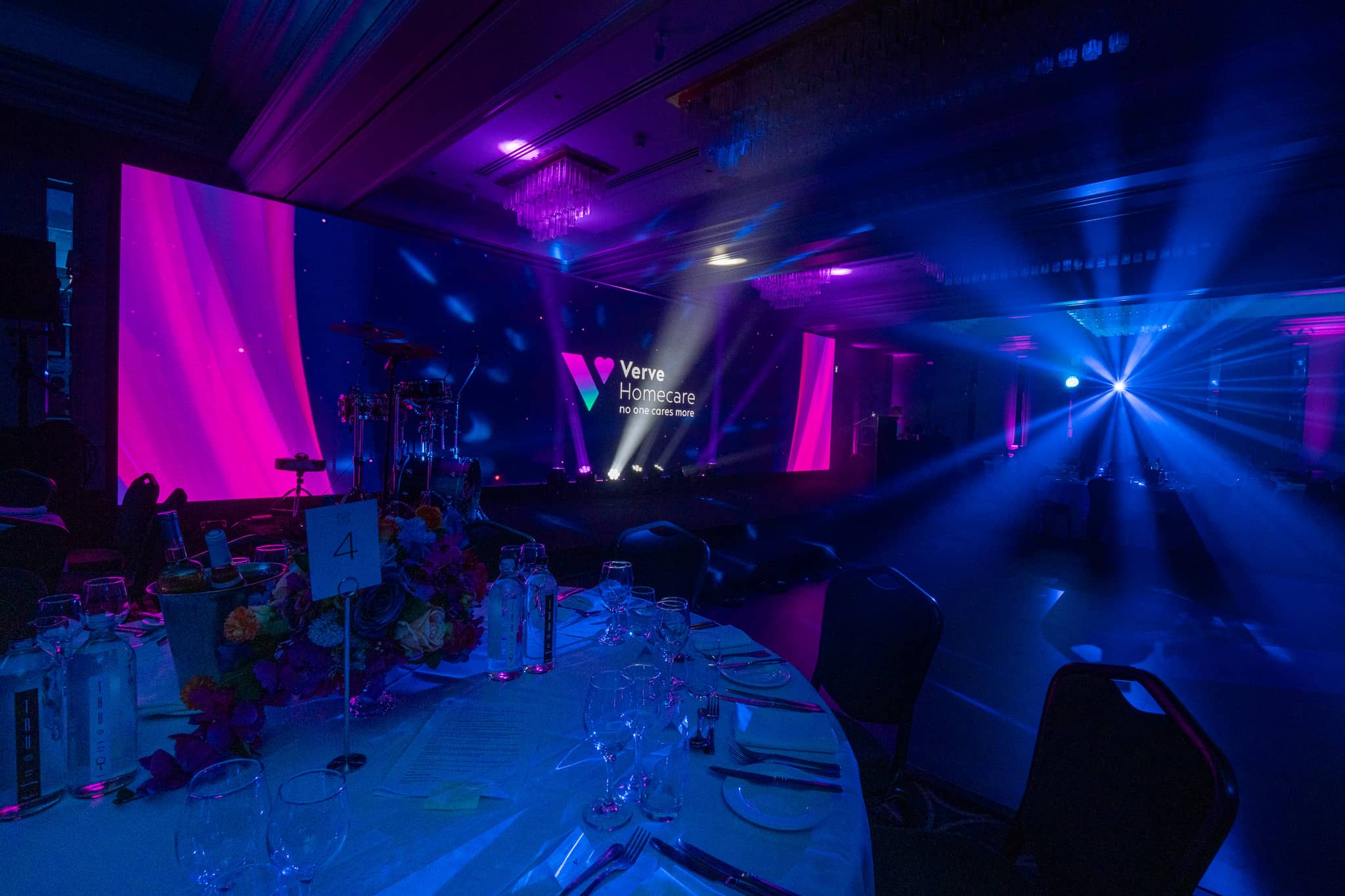 Beam lighting and haze across the dinner tables towards the Verve Homecare stage at Sopwell House for Verve Awards Night.