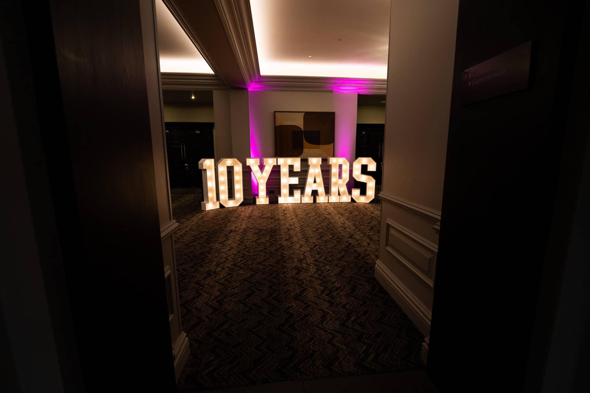 The 10 YEARS marquee letters framed through the doorway into the foyer at Sopwell House, lit for Verve Awards Night.
