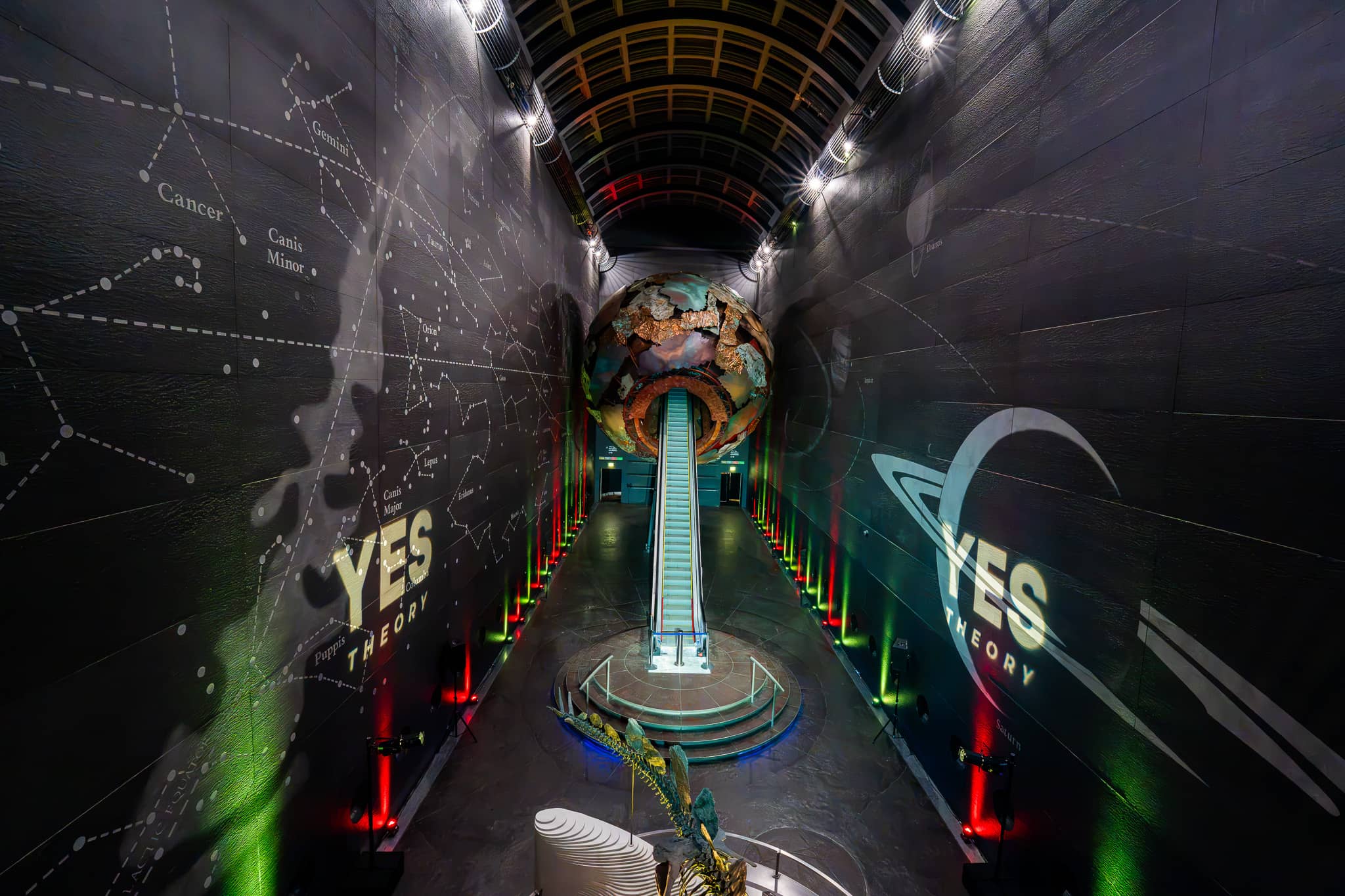 The Earth sculpture lit at the end of Earth Hall with constellation patterns across the walls, Yes Theory 10 million subscriber celebration by Kudos AV.