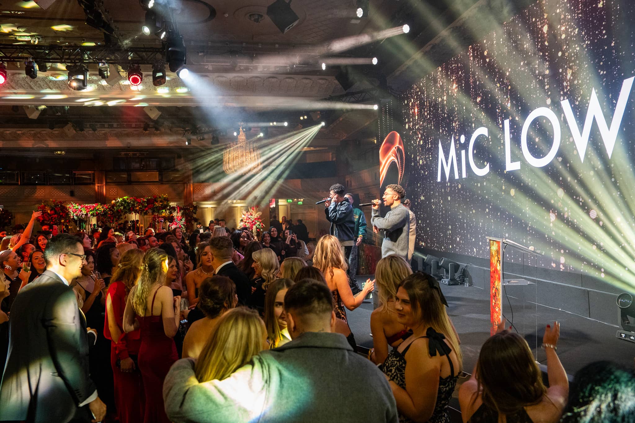 Guests dancing in front of the stage during MiC LOWRY’s set, the LED screen and lighting rig above, Dental Beauty Partners Awards 2025 in the Great Room at Grosvenor House London, by Kudos AV.