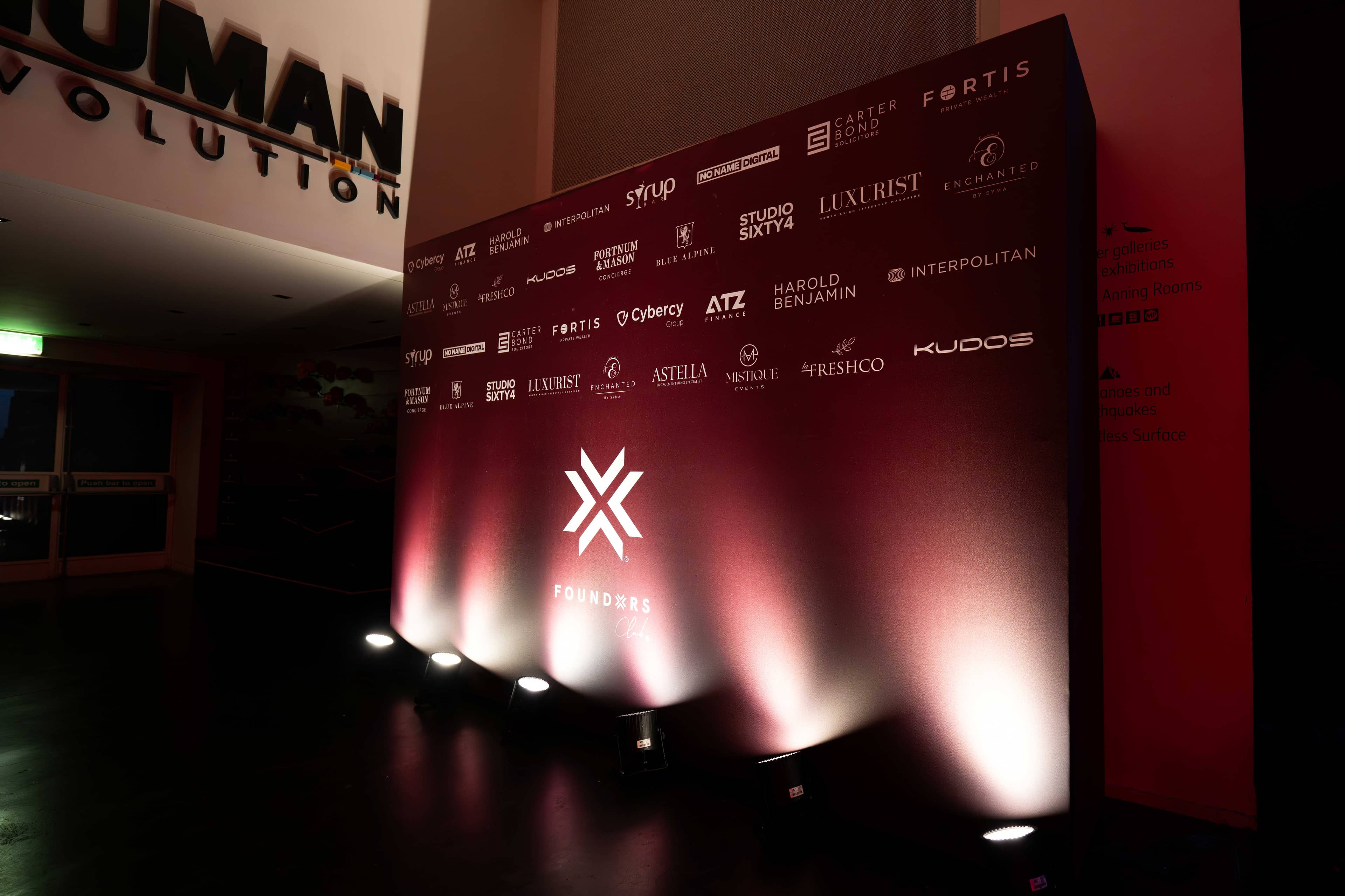The FOUNDXRS partner wall in red with white light across it, FOUNDXRS Club black tie party in Earth Hall by Kudos AV.