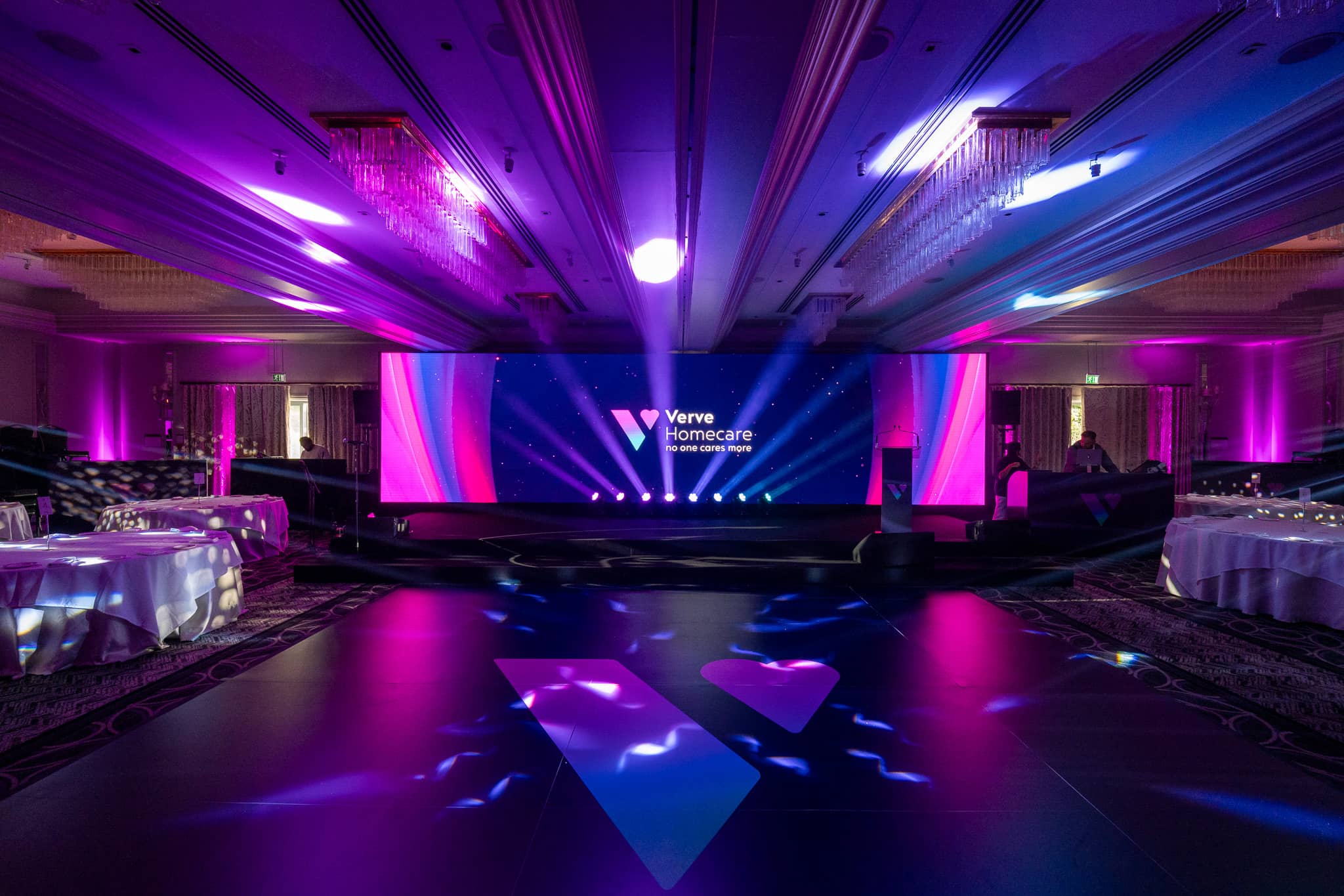 Wide view of the St Alban Suite at Sopwell House for Verve Awards Night, with magenta uplighting, moving head beams, a 10m LED wall and the Verve logo on the dancefloor.