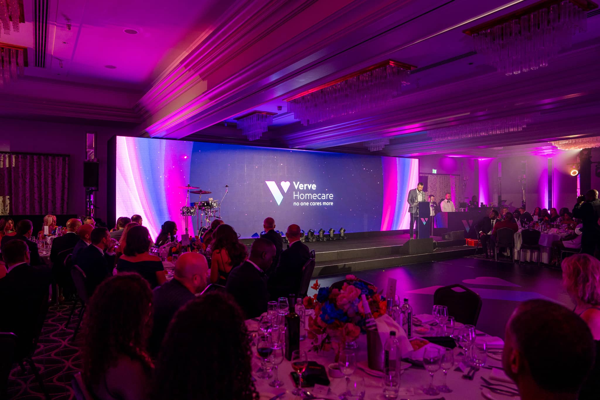 Guests at dinner in the St Alban Suite during Verve Awards Night, with presenters on stage in front of the Verve Homecare LED wall.