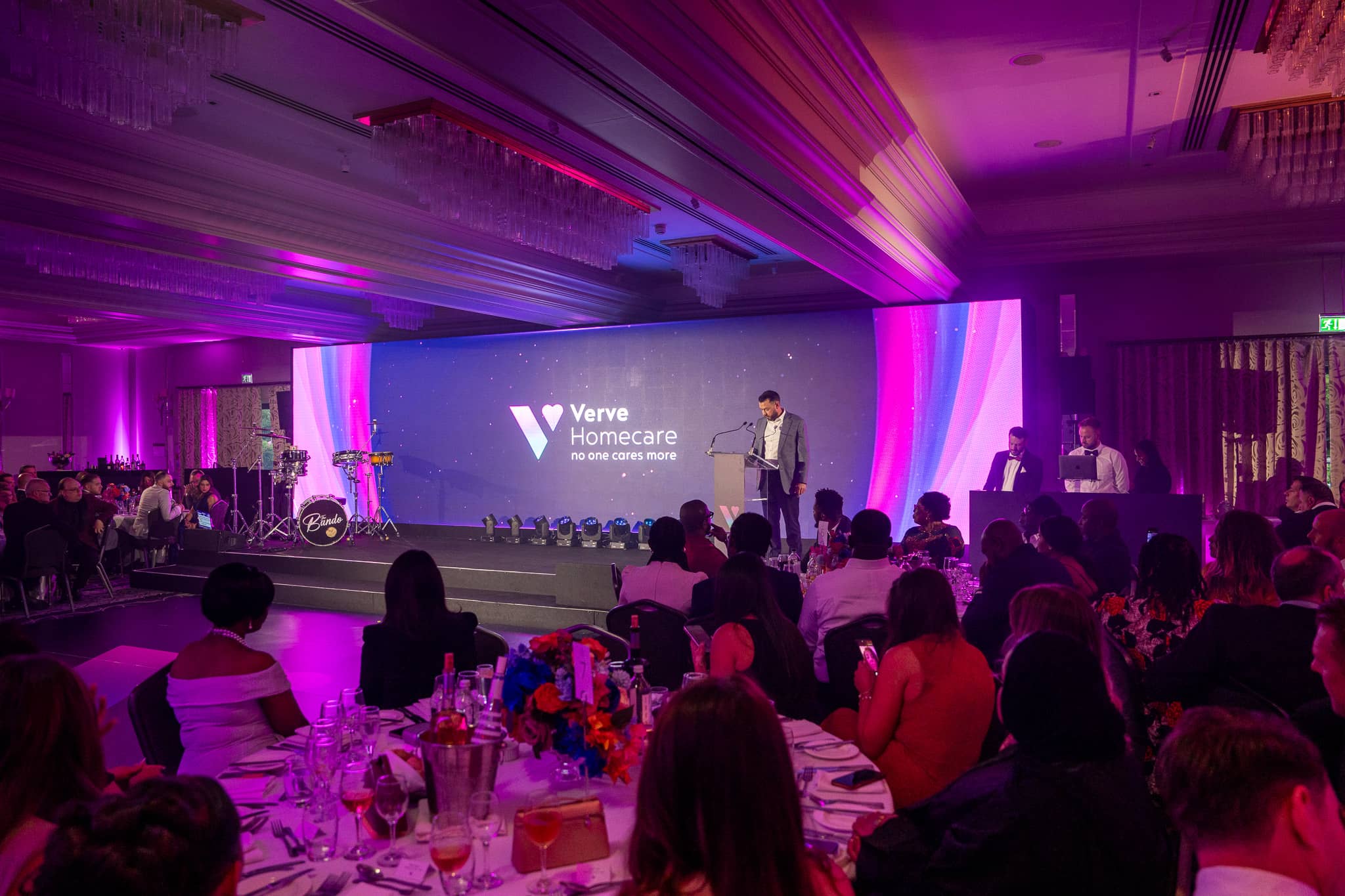 A full St Alban Suite watches the Verve Awards Night stage at Sopwell House, with the Verve Homecare LED wall, magenta uplighting and chandeliers overhead.