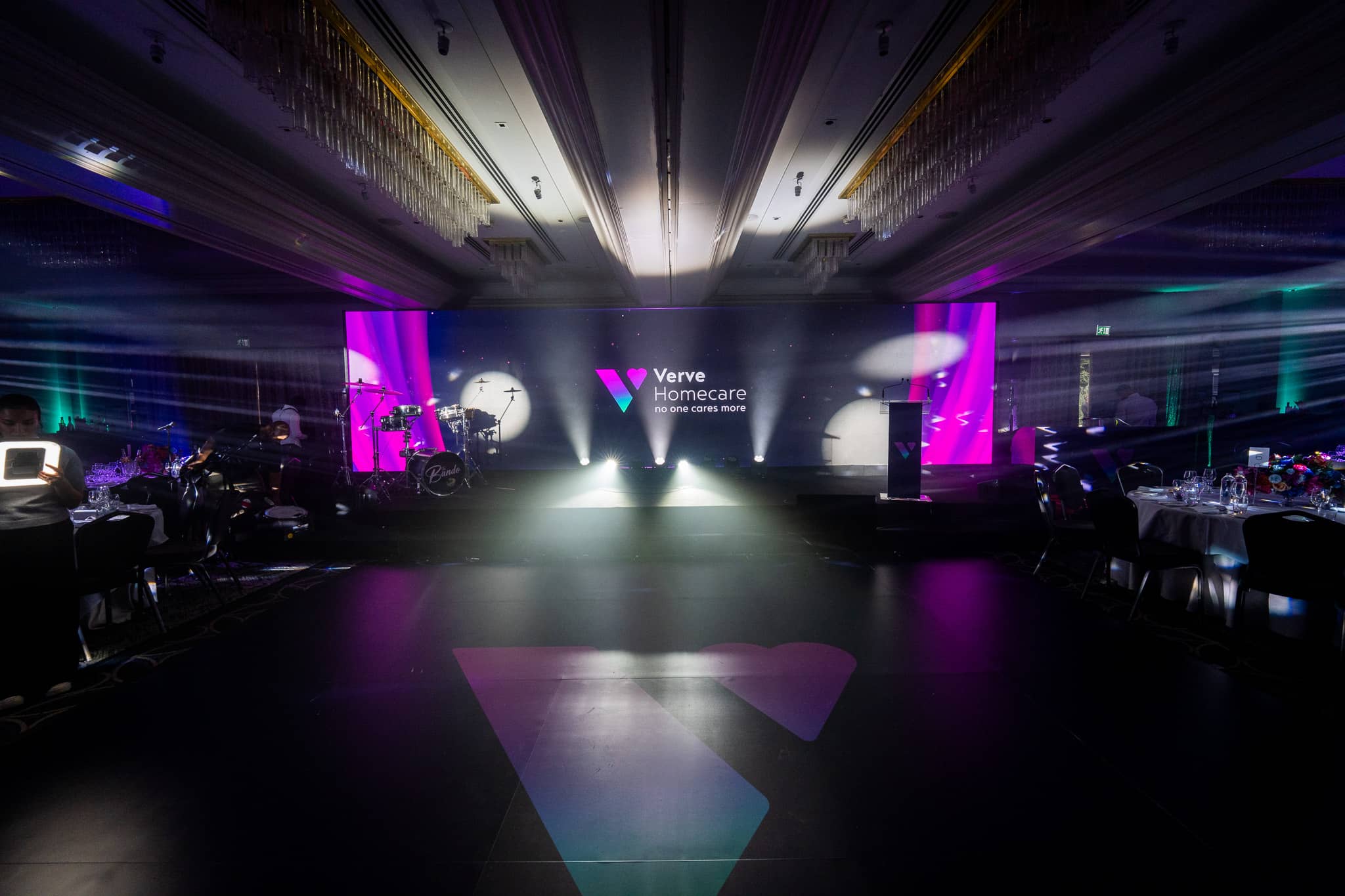 White beams light the awards stage and band setup beneath the chandeliers in the St Alban Suite at Sopwell House for Verve Awards Night.