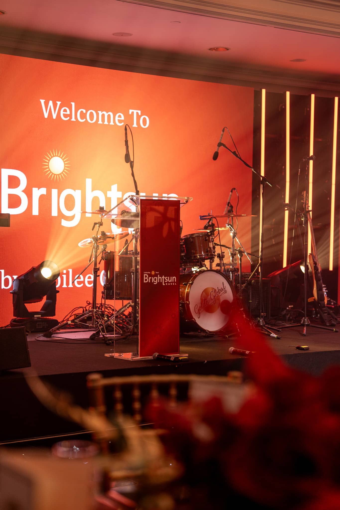 Brightsun’s printed lectern in front of the anniversary welcome graphic and band equipment, at Brightsun Travel’s 40th anniversary at InterContinental London Park Lane.