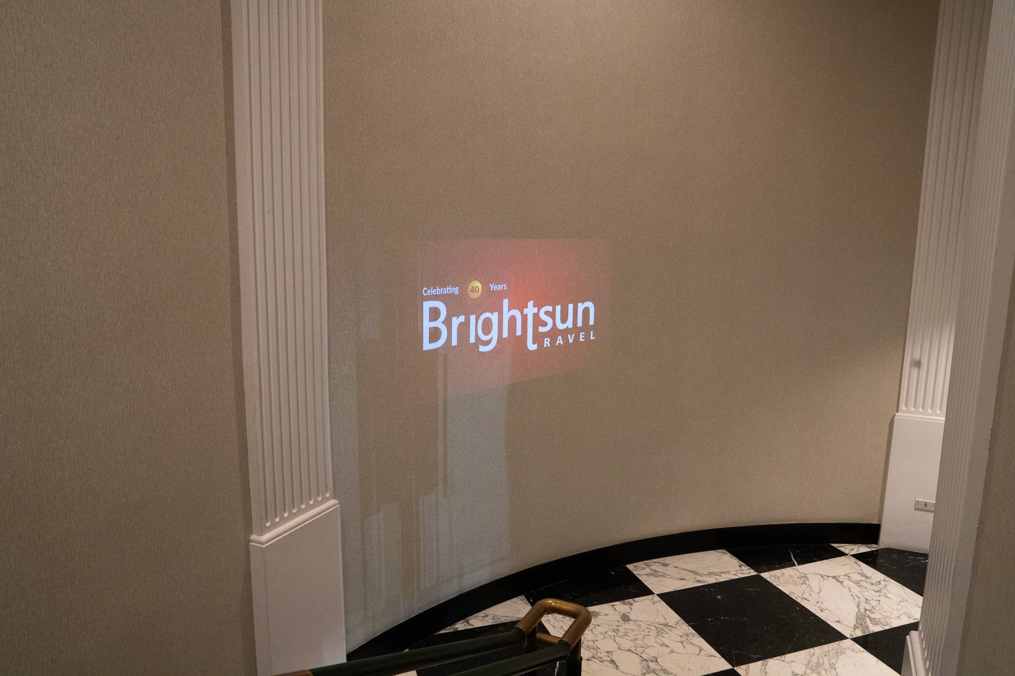 Brightsun Travel logo projected onto a foyer wall beside the marble floor, at Brightsun Travel’s 40th anniversary at InterContinental London Park Lane.