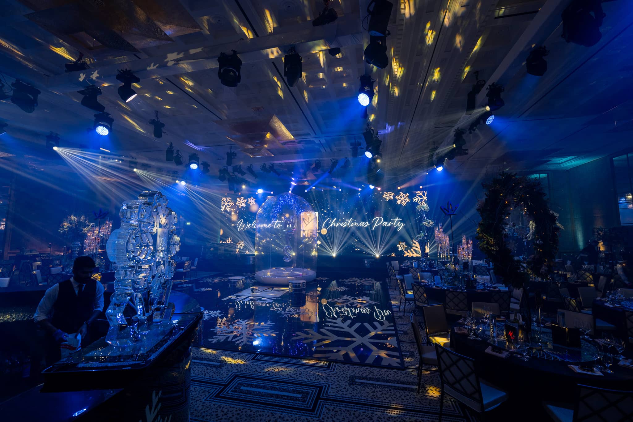 Wide view of blue lighting, dinner tables and the MFS printed dancefloor at The Peninsula London