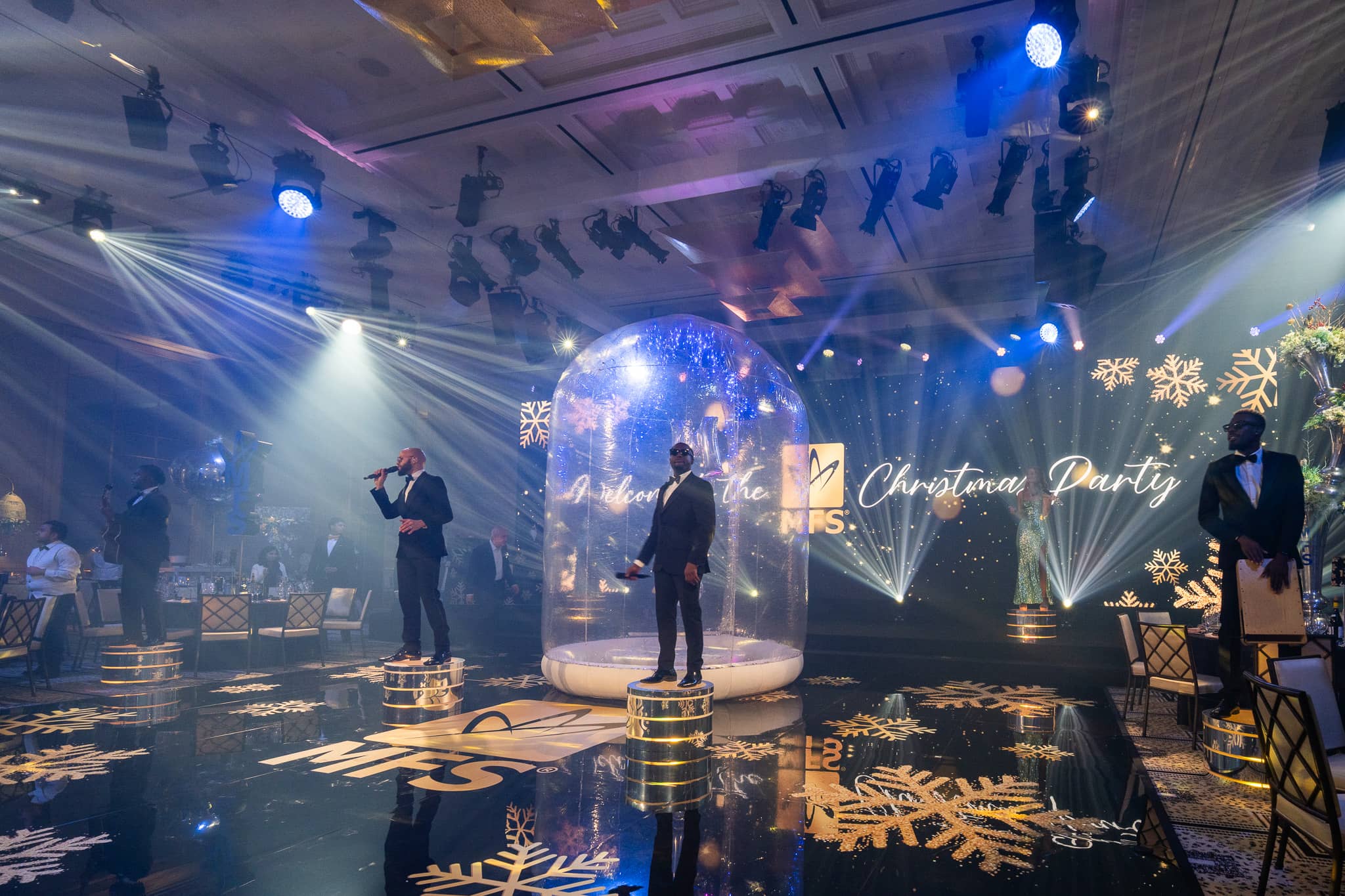 Live vocalists perform beside the snow globe on the MFS printed dancefloor under white beams