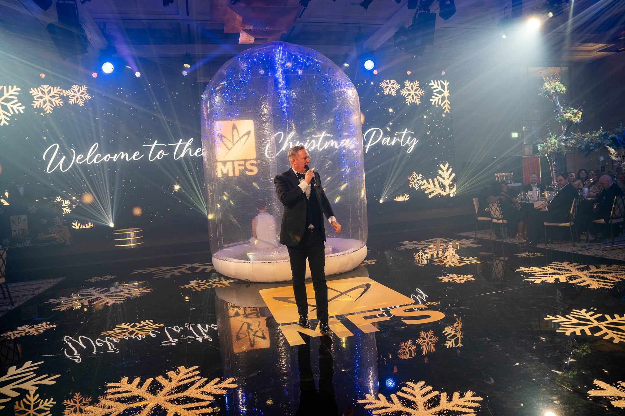 A vocalist performs on the MFS printed dancefloor beneath the Christmas party LED screen