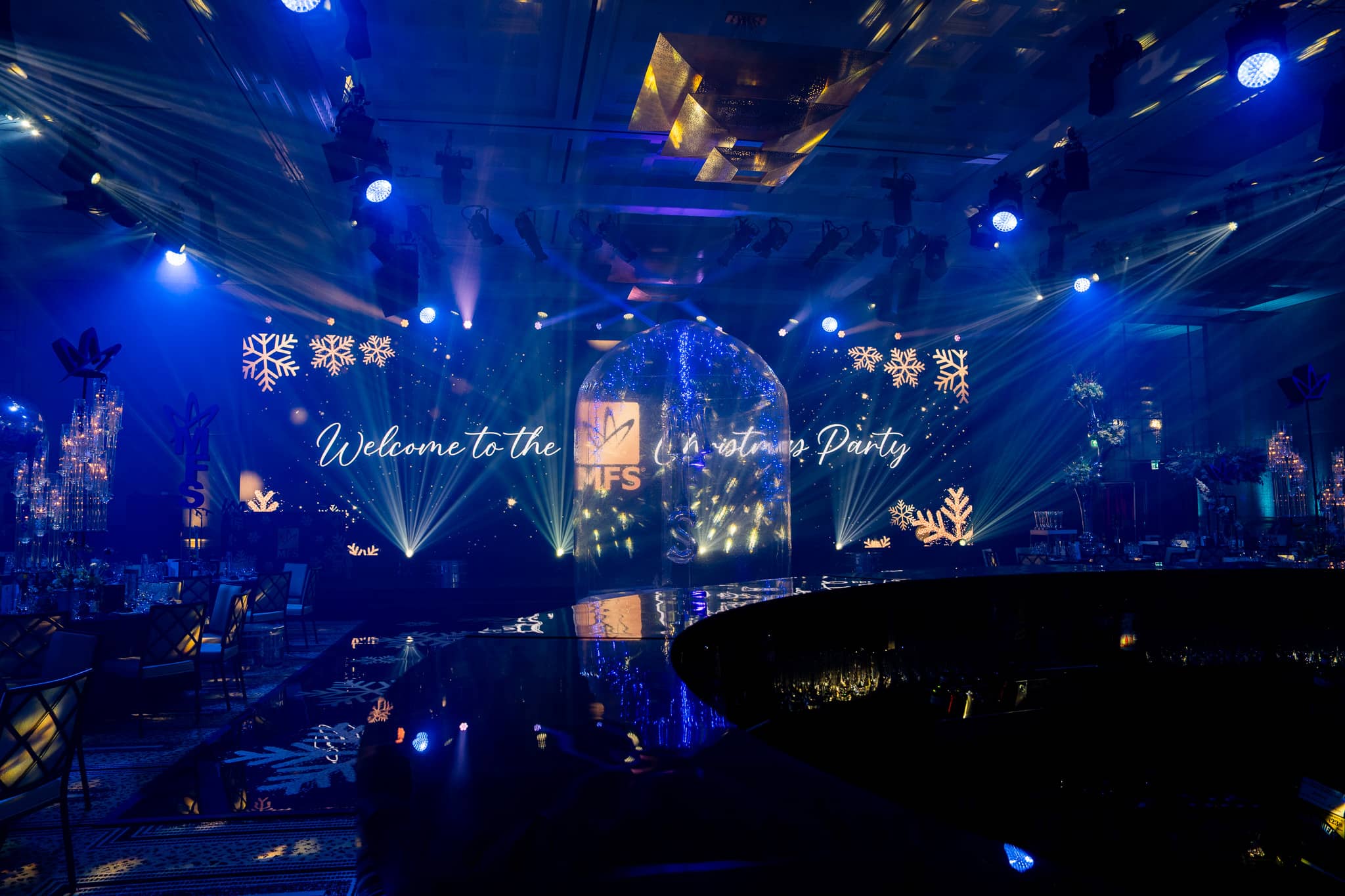 Blue stage lighting around the snow globe and MFS LED screen at The Peninsula London