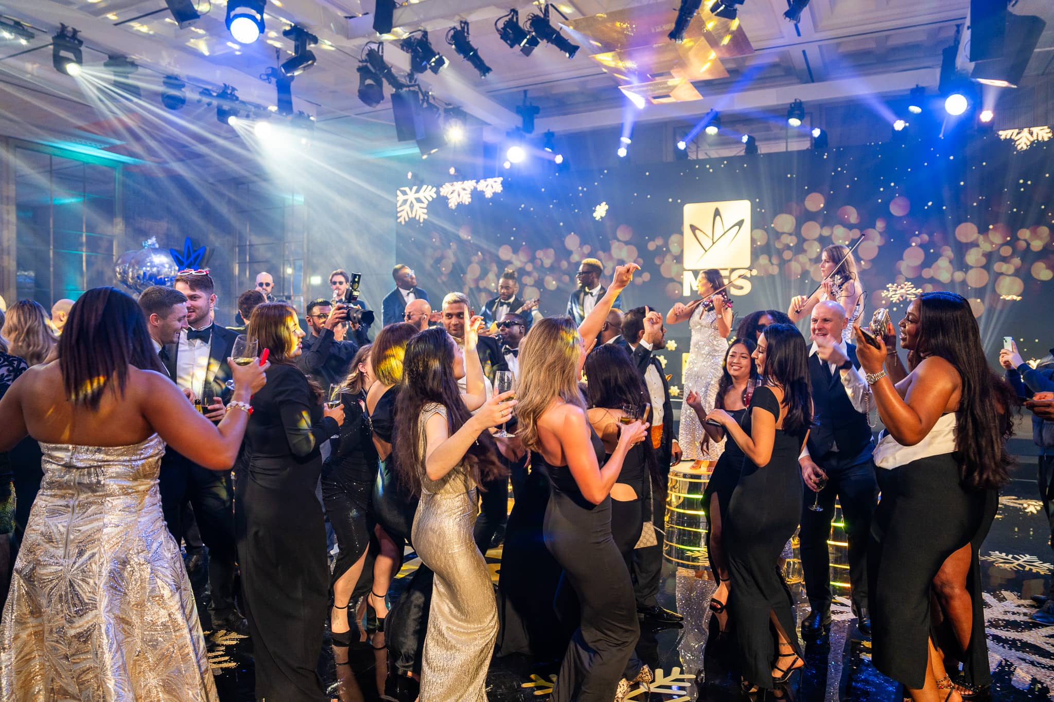 Guests dancing in front of The Function Band and the gold MFS screen at The Peninsula London