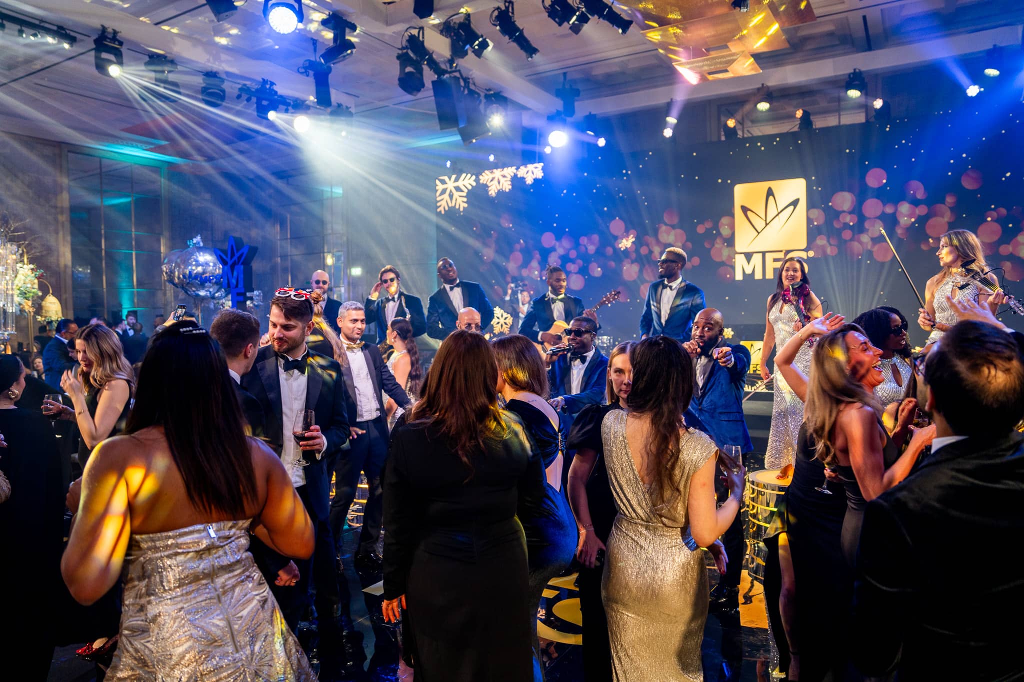 Guests dance with The Function Band performing behind them under blue and white lighting
