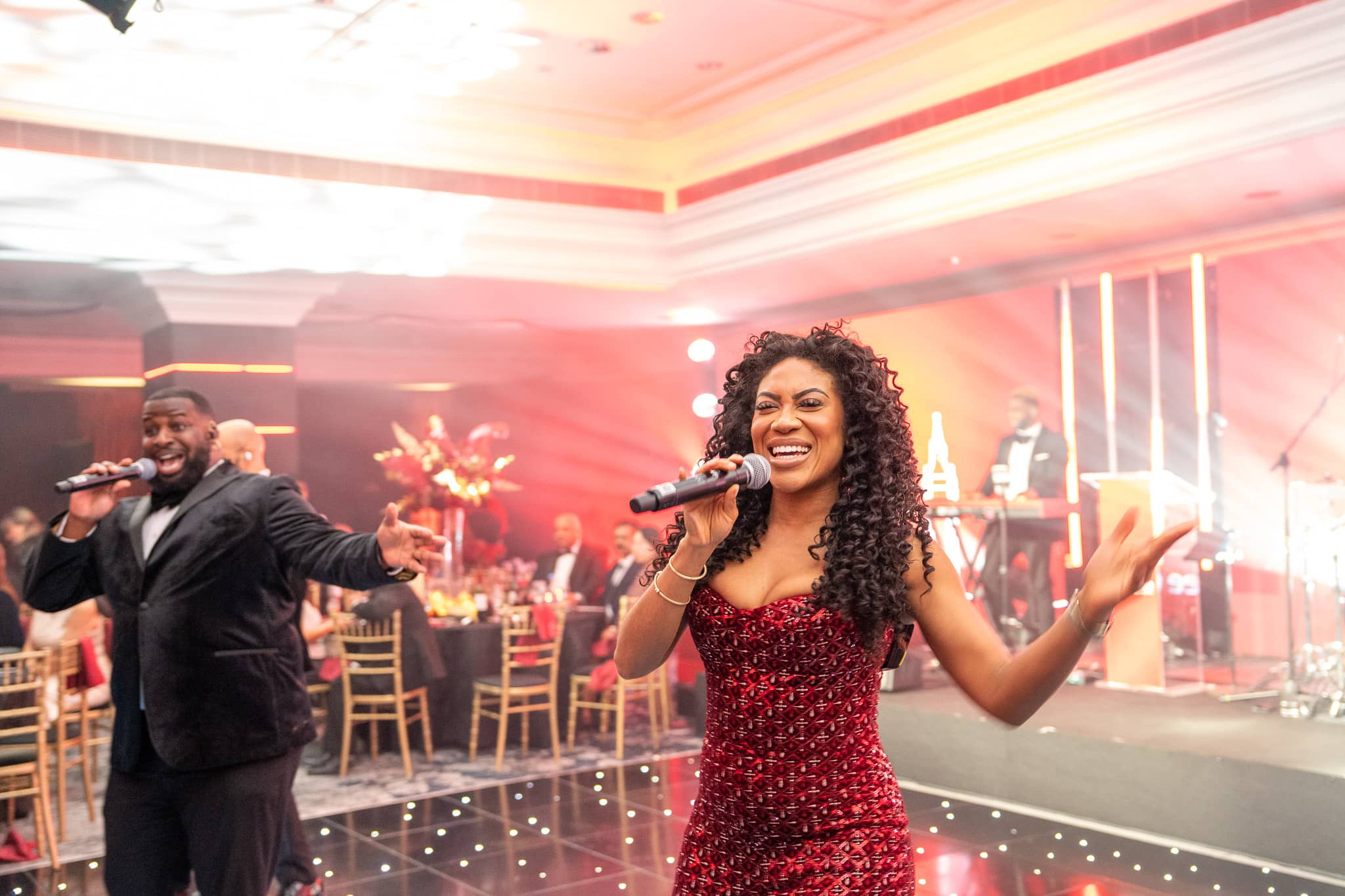 Goldn Global’s singers performing among the guests with the stage behind them, at Brightsun Travel’s 40th anniversary at InterContinental London Park Lane.