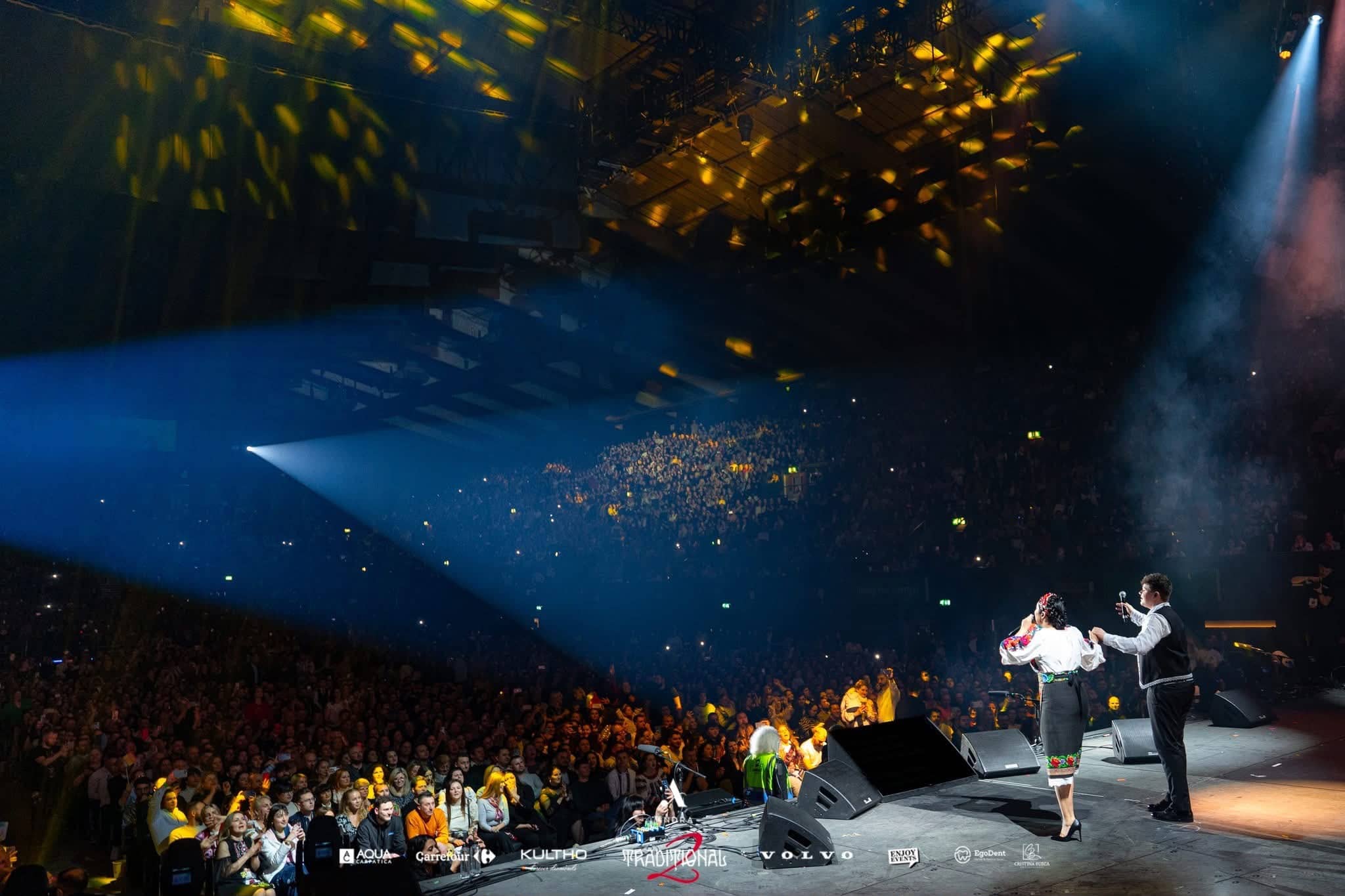 Andra and a guest singing together at the edge of the stage, gobos across the crowd and haze in the beams, Andra Traditional 2 at OVO Arena Wembley, lit by Kudos AV.