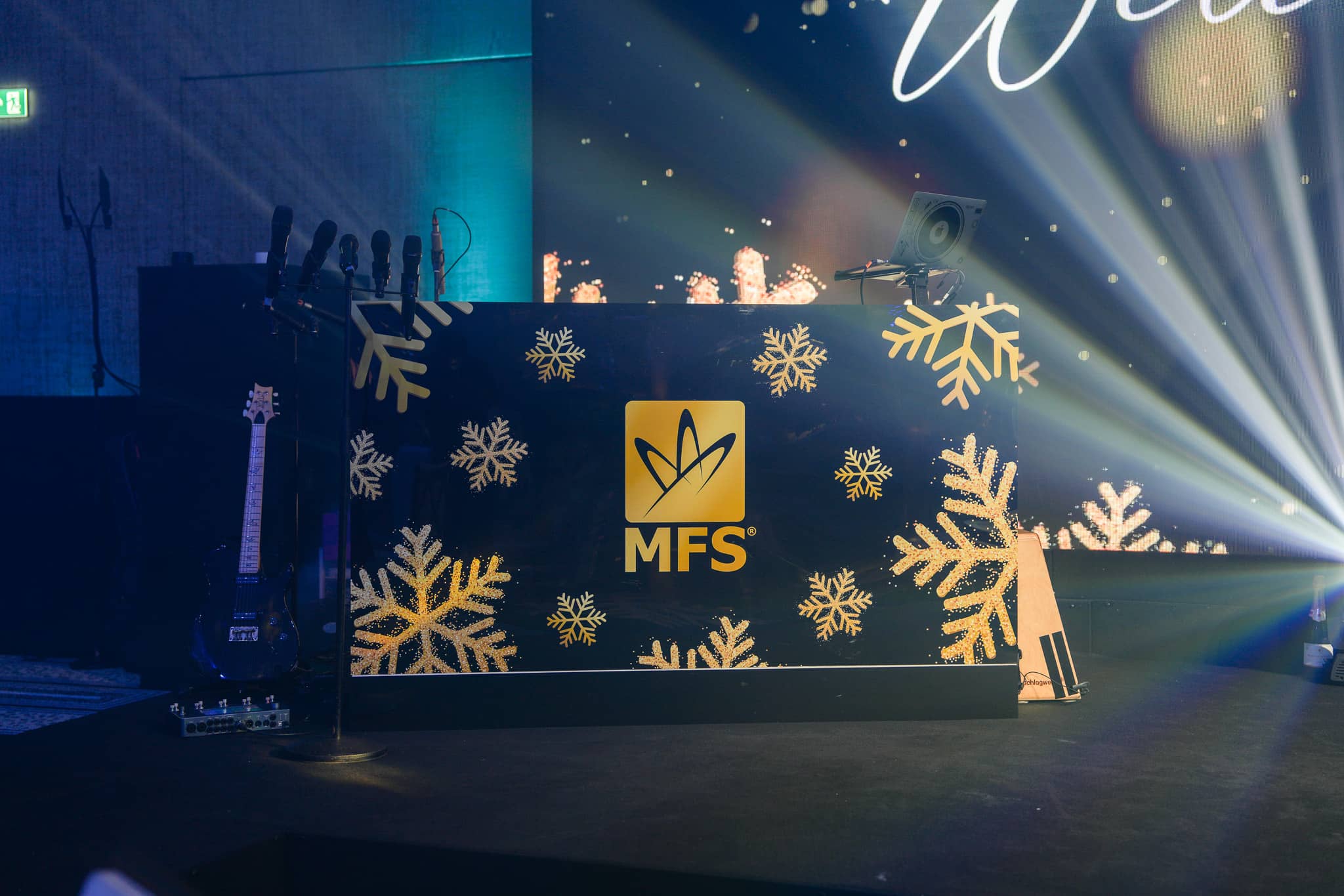 MFS branding and gold snowflakes on the DJ front, with white beams behind at The Peninsula London