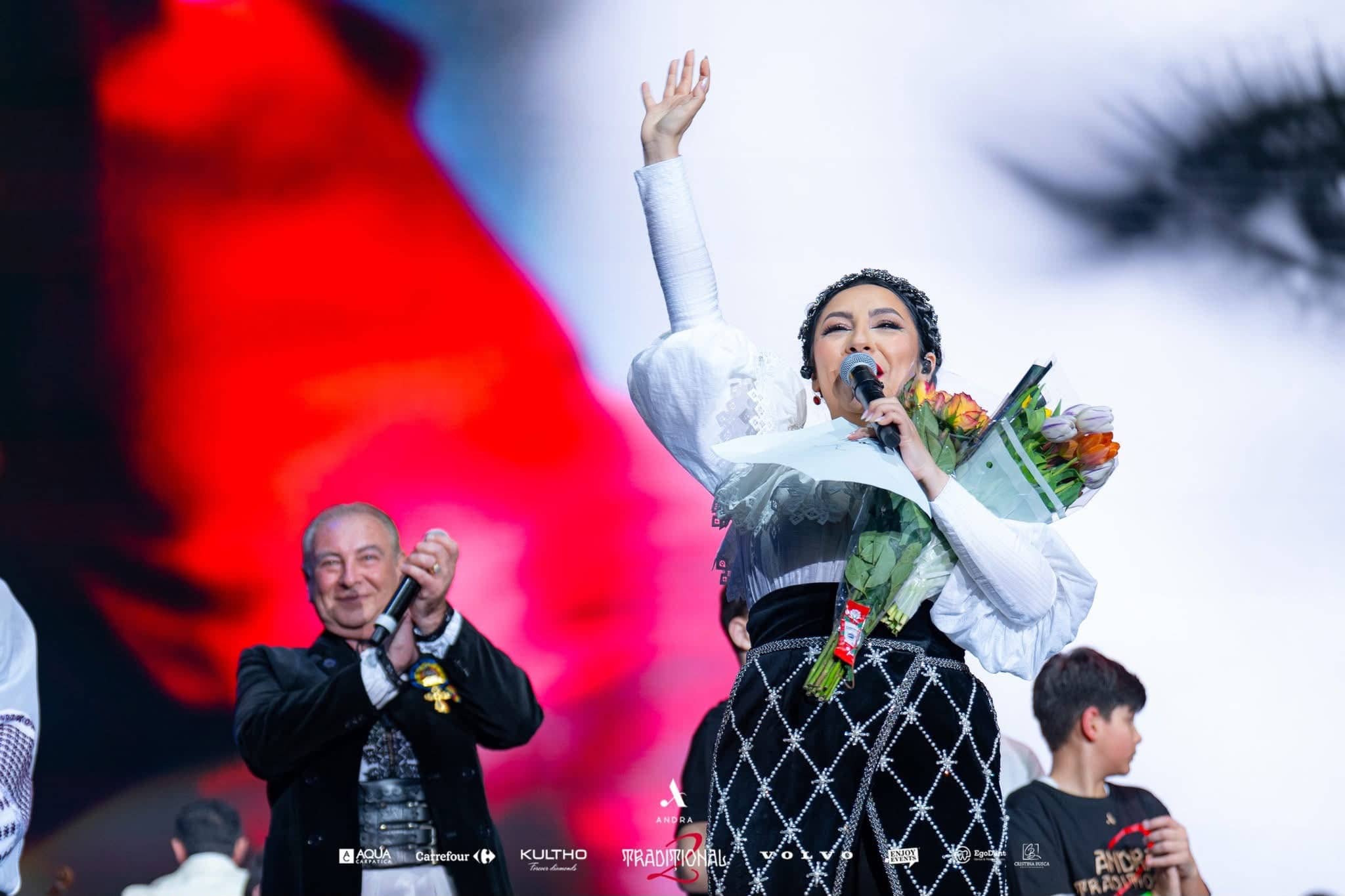 Andra holding flowers and raising her fist in front of the LED wall as a guest applauds, Andra Traditional 2 at OVO Arena Wembley, LED screens by Kudos AV.