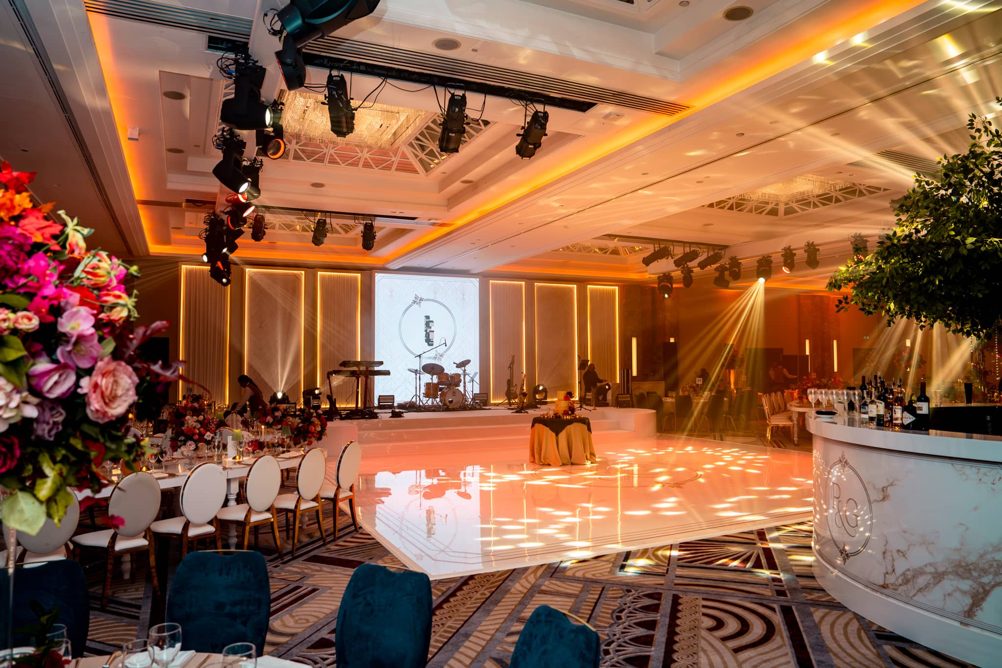 Royal Lancaster London ballroom with overhead lighting, white dancefloor, LED stage and printed round bar.