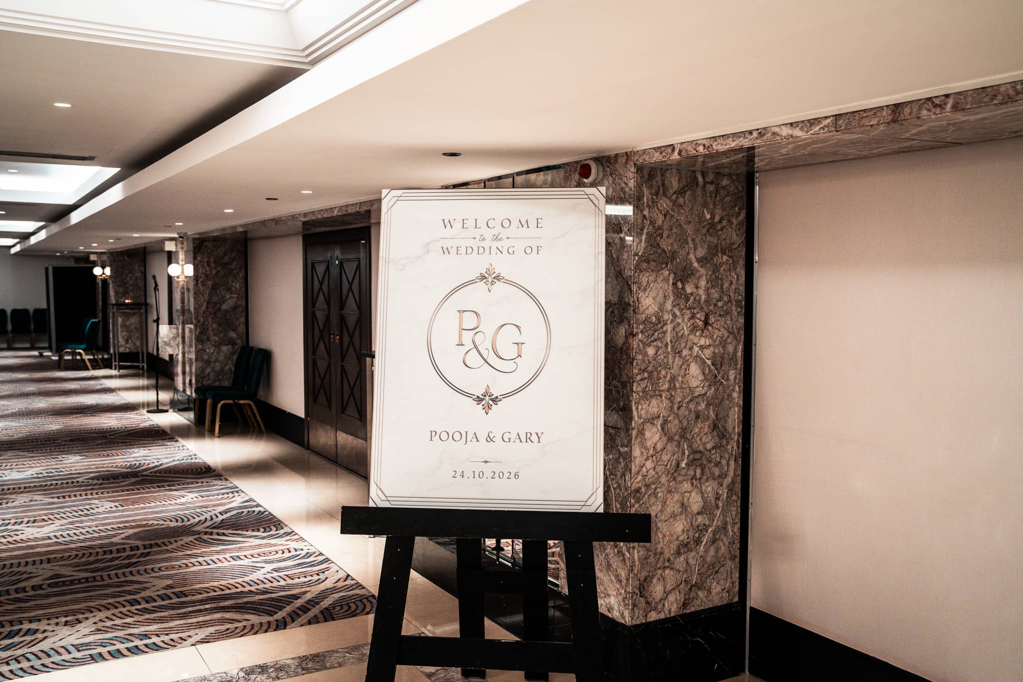 Printed welcome sign for Pooja and Gary on an easel in the Royal Lancaster London foyer.