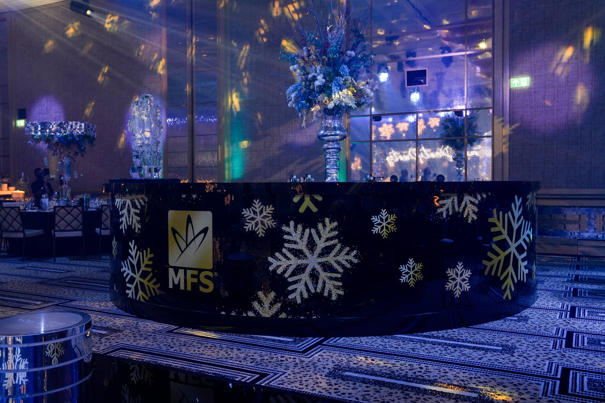 Wide view of the MFS printed bar under blue ballroom lighting at The Peninsula London