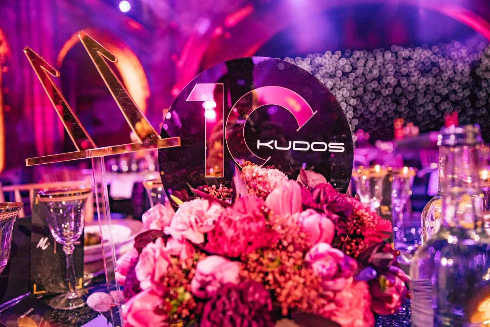 Kudos 10 at the Natural History Museum, a 10 KUDOS gold table centrepiece with florals, by Kudos AV
