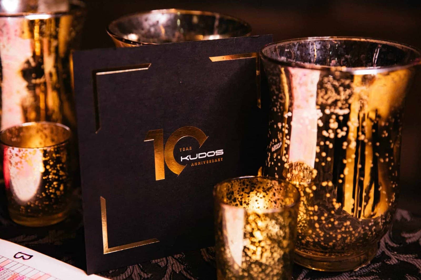 Kudos 10 at the Natural History Museum, branded 10 year anniversary menu and candle styling, by Kudos AV