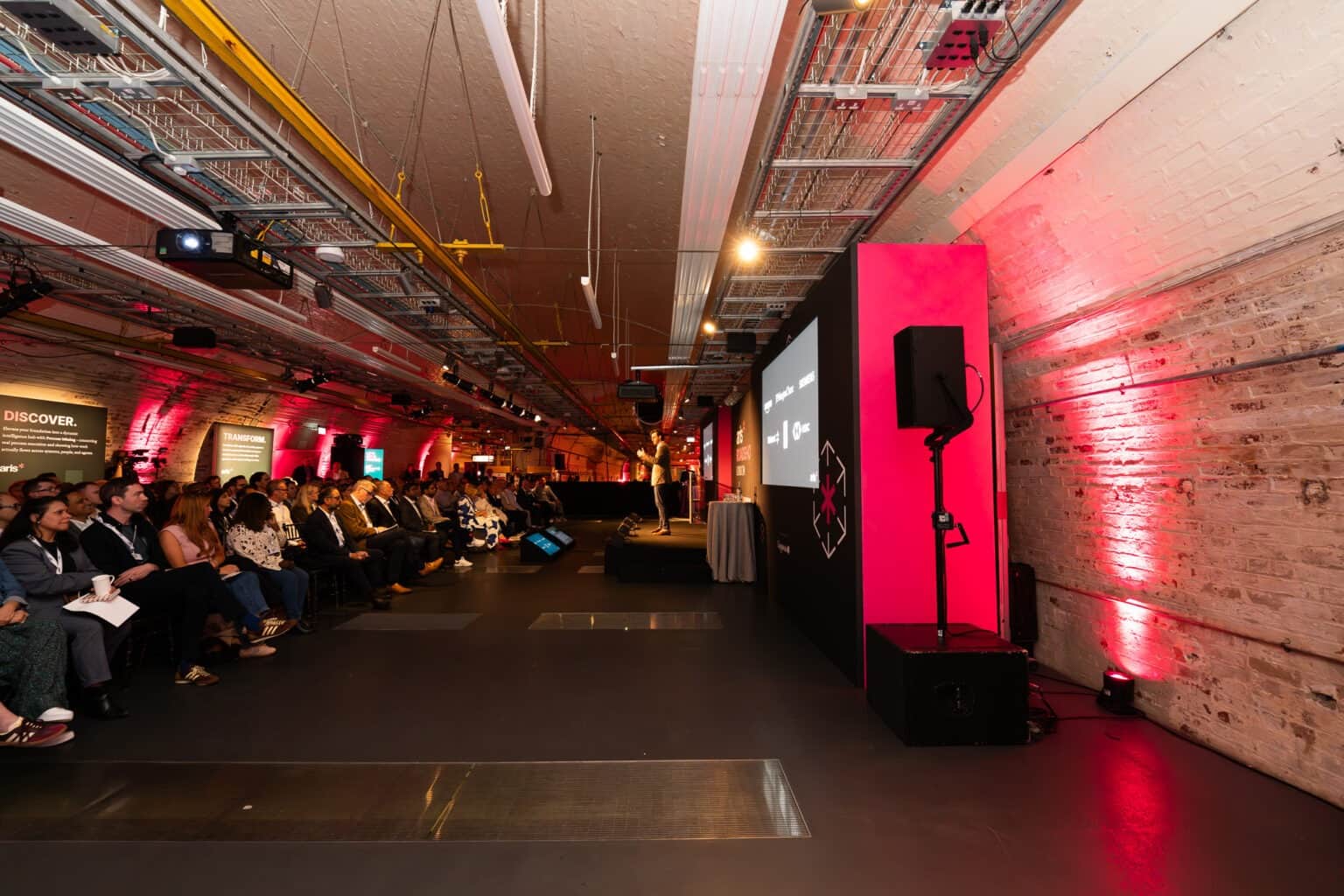 A corporate conference set with staging, presentation screens and lighting, produced by Kudos AV in London