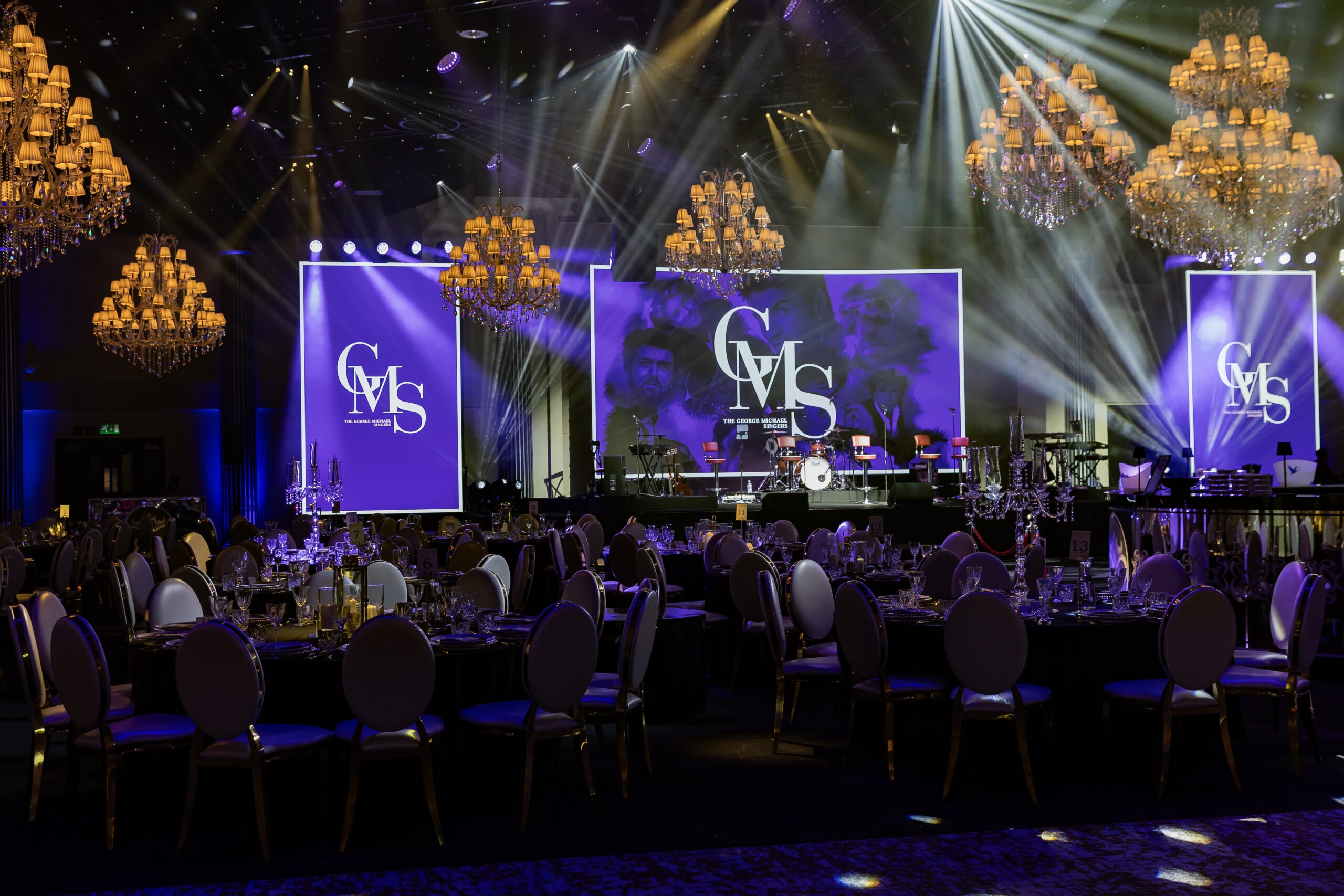 Wide view of The George Michael Singers Live gala at IXL Events Centre: 240-cover dinner with purple beam lighting and LED screens, Kudos AV production